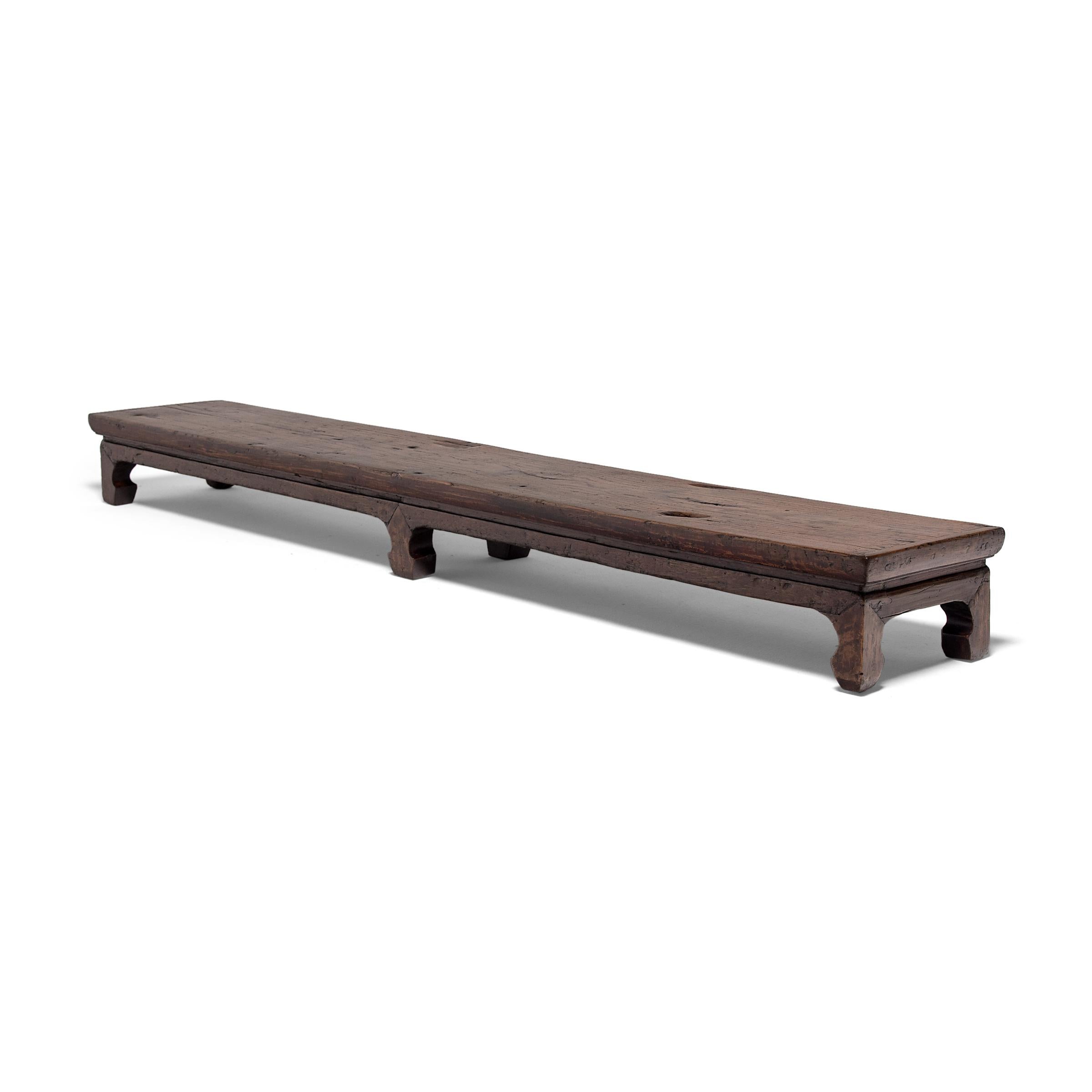 Designed to resemble the low tables placed atop a kang platform, this 19th-century low bench from Henan province is actually a step used for easily getting in and out of a raised daybed. Constructed of richly aged northern elmwood (yumu), the