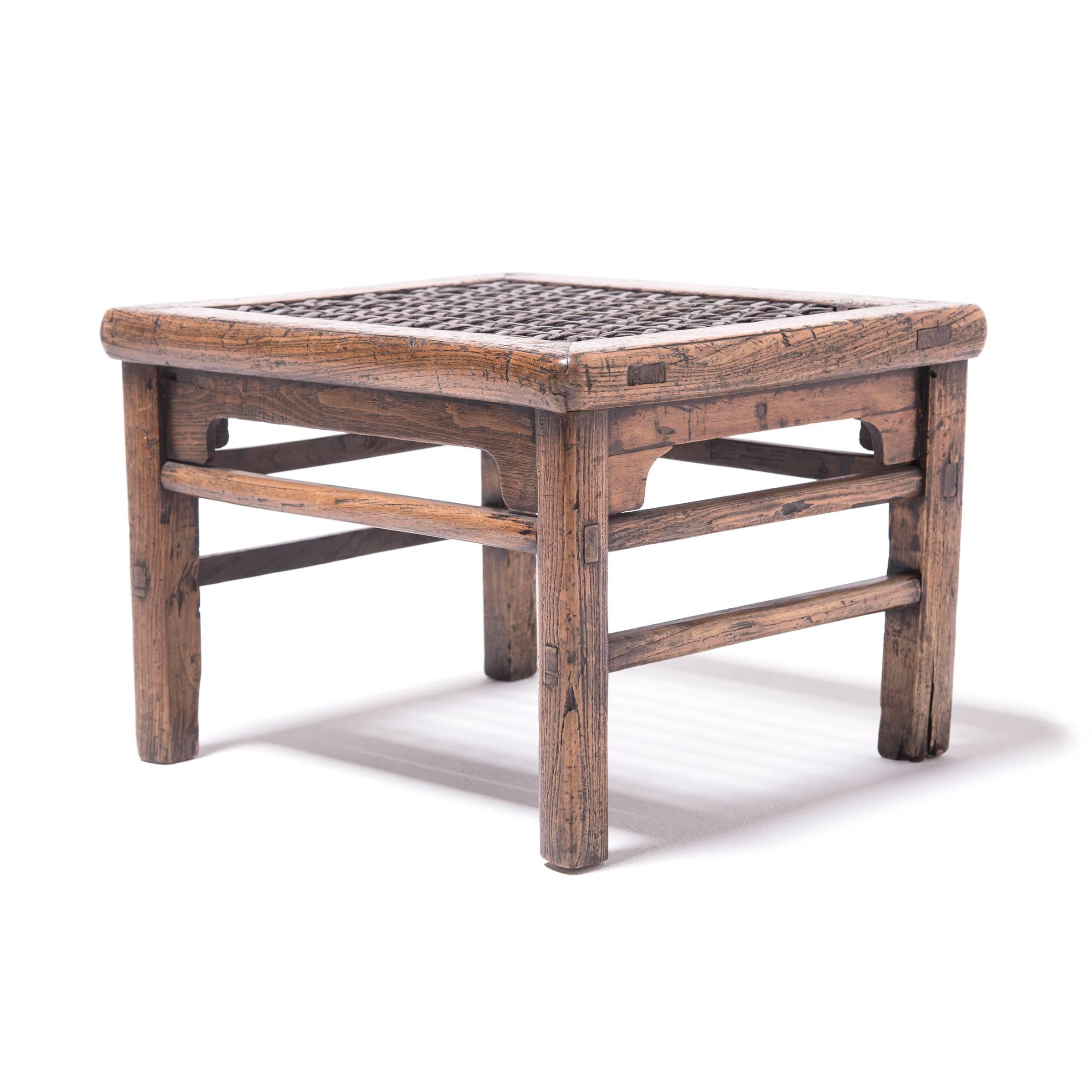 The top of this stool was woven with incredible care by a skilled artisan who used thin strips of hide to create multiple patterns in the seat, including stars. The hand-hewn elmwood stool with exposed joinery was crafted in Northern China over 150
