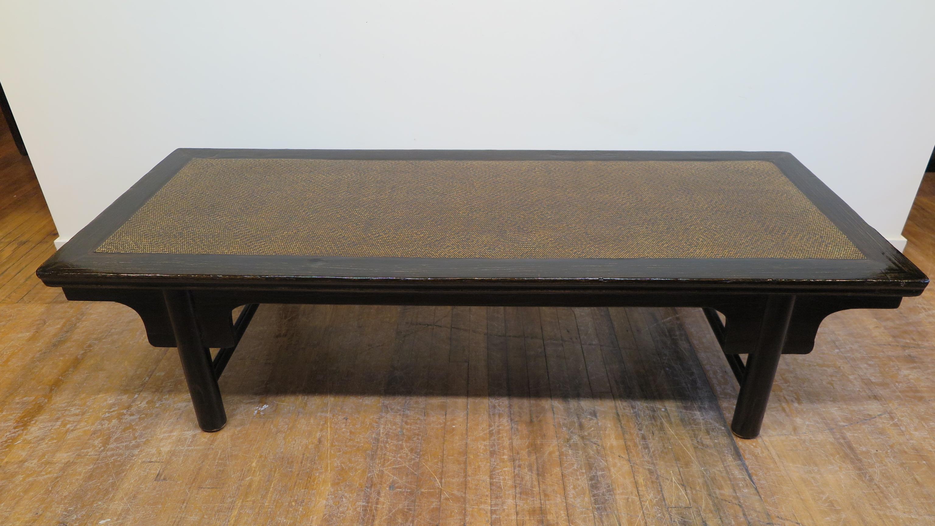 19th century Chinese day bed, coffee, cocktail table. Worn ebony color highlights a rich Elm wood frame with rattan matt top having hand applied lacquer finish. Simple details of a shadow apron with spandrel outline the entire table. Having