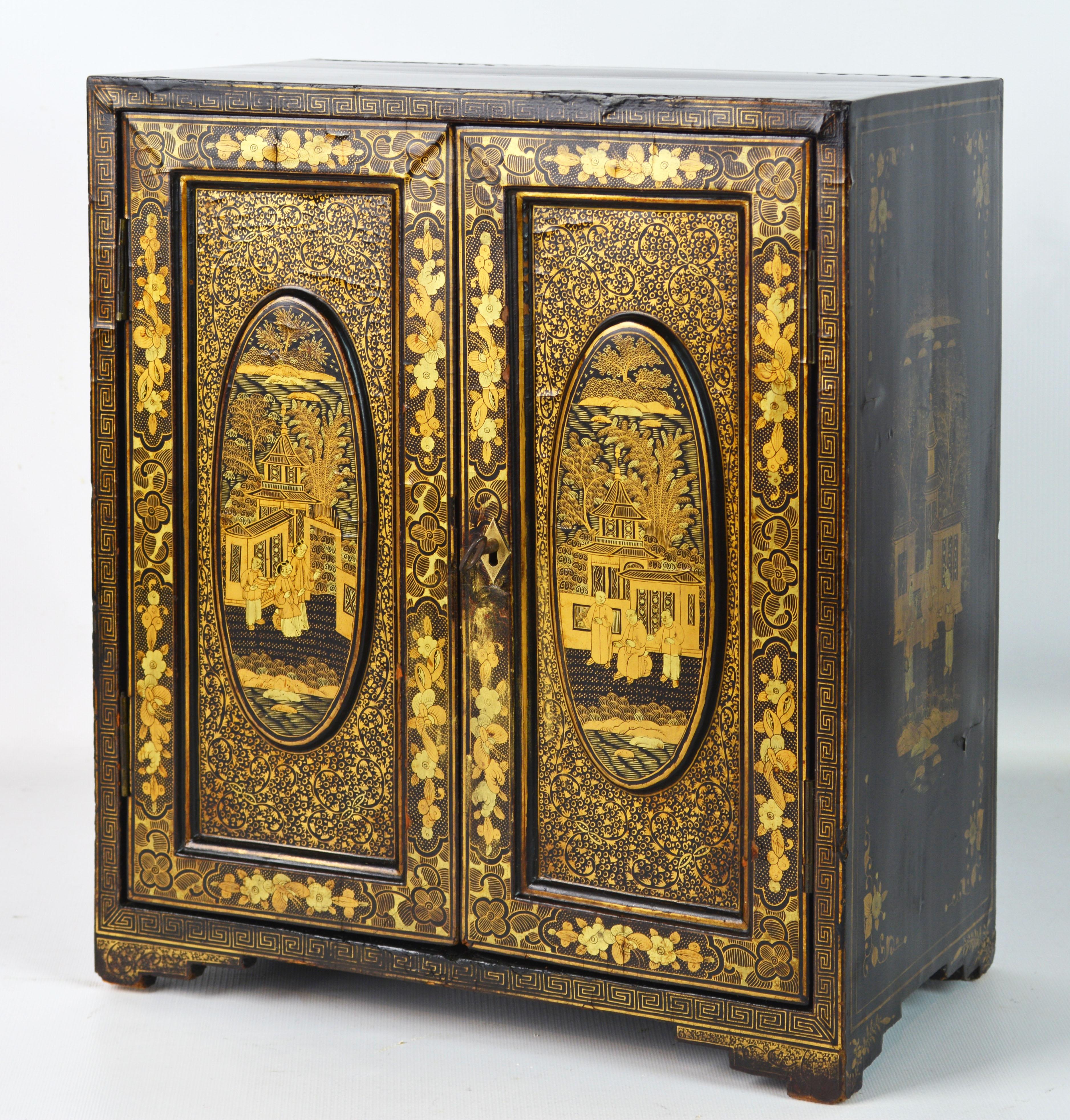 This little Chinese gem features two richly gilt decorated doors that open up to an interior fitted with 5 likewise decorated drawers and bone knobs. Resting on a carved gilt decorated Ming style base the cabinet features hand painted gilt