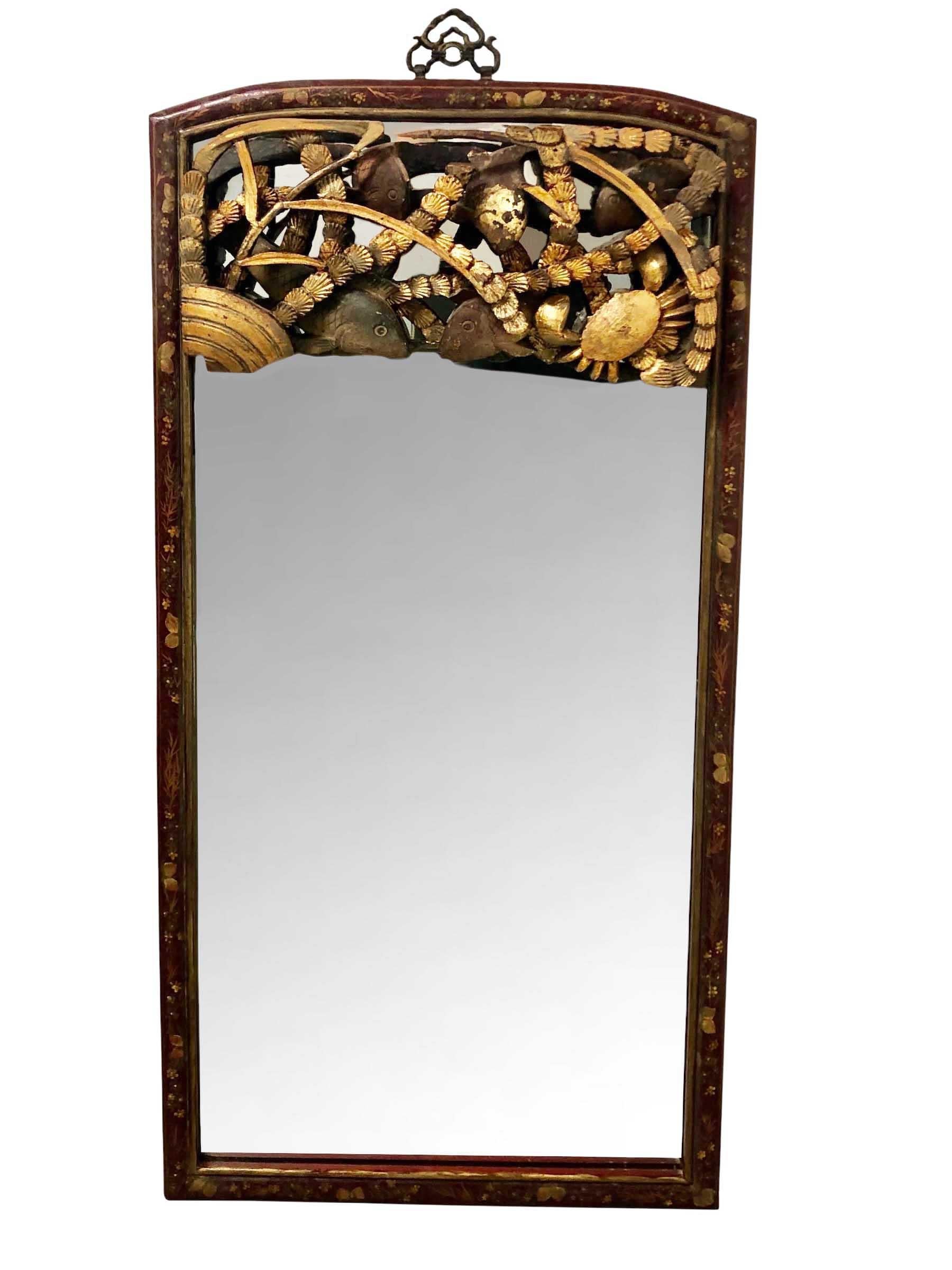 1900s hand painted mirror with pomegranates and flowers in the Chinese taste surround the mirror. An early 19th century gold fragment of koi fish, crab and seaweed is at the top. There's a decorative brass holder for hanging.