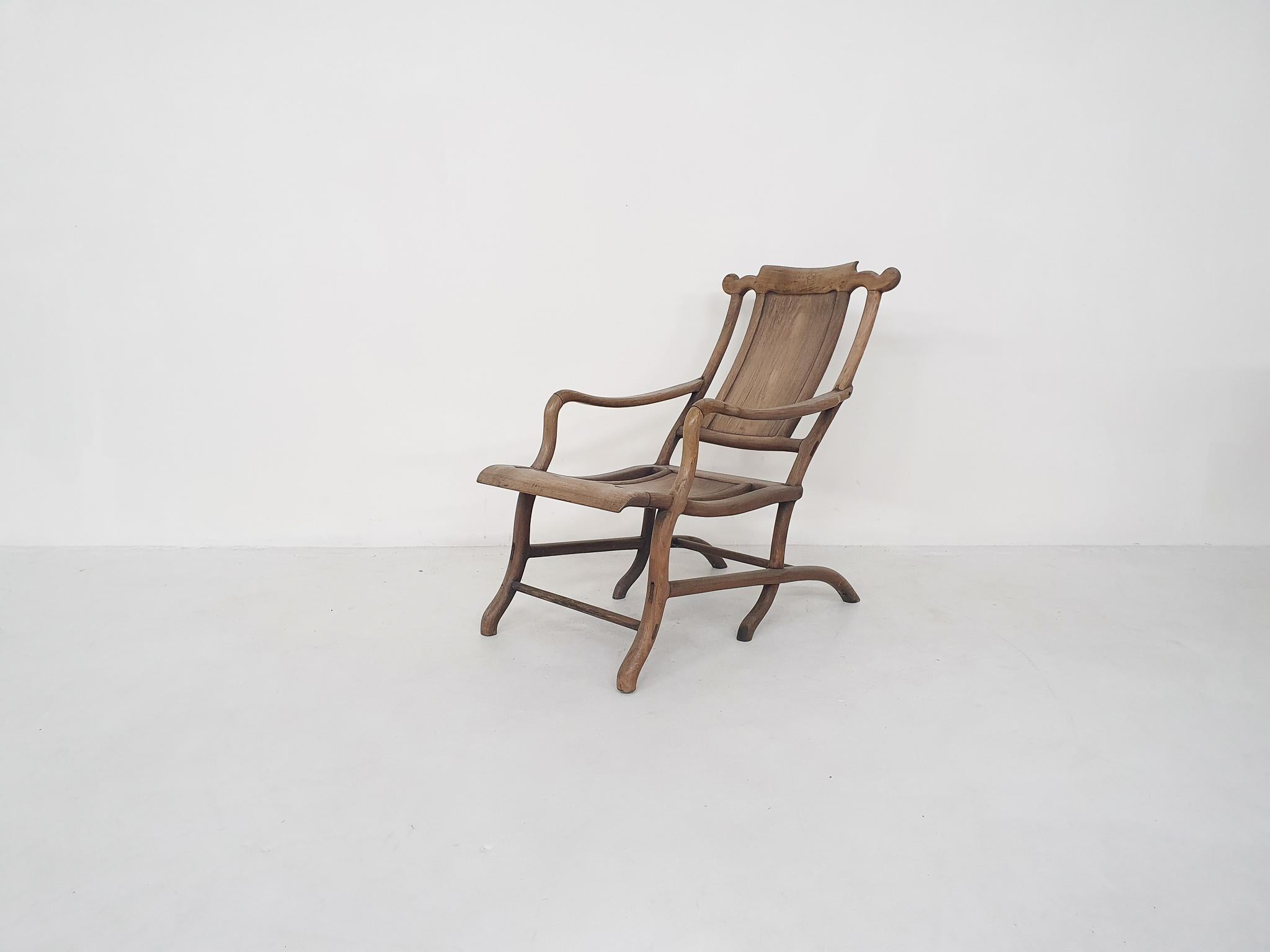Sculptural solid wooden lounge chair. The laquer has turned a bit white trough the years, but this gives a nice patina to the chair.