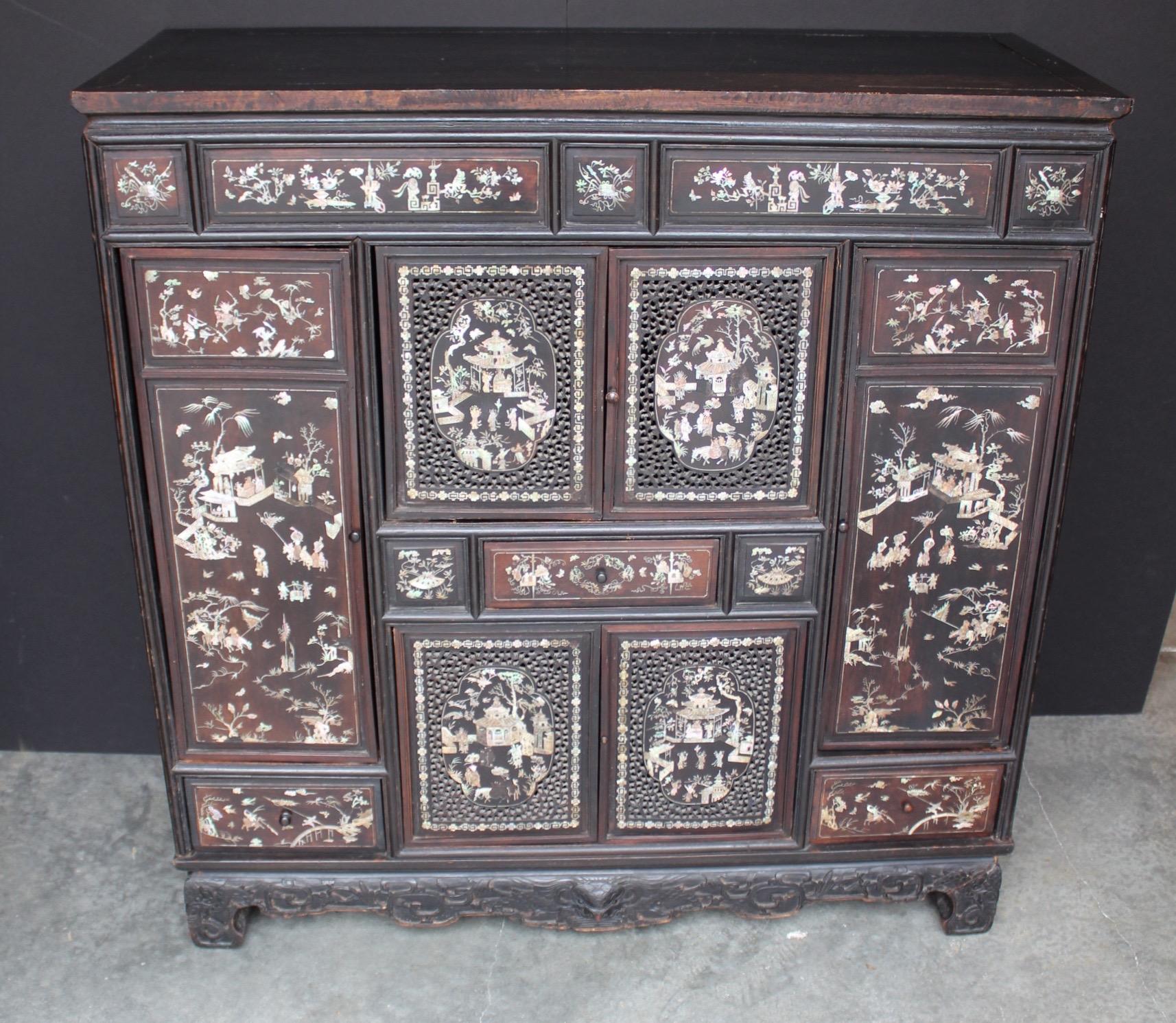19th century Chinese cabinet of exceptional design and truly stunning mother-of-pearl inlay work. This ebonized wood cabinet representing diverse Chinese Scenery.
Opens by six carved doors with inside shelves and three drawers for storage carved