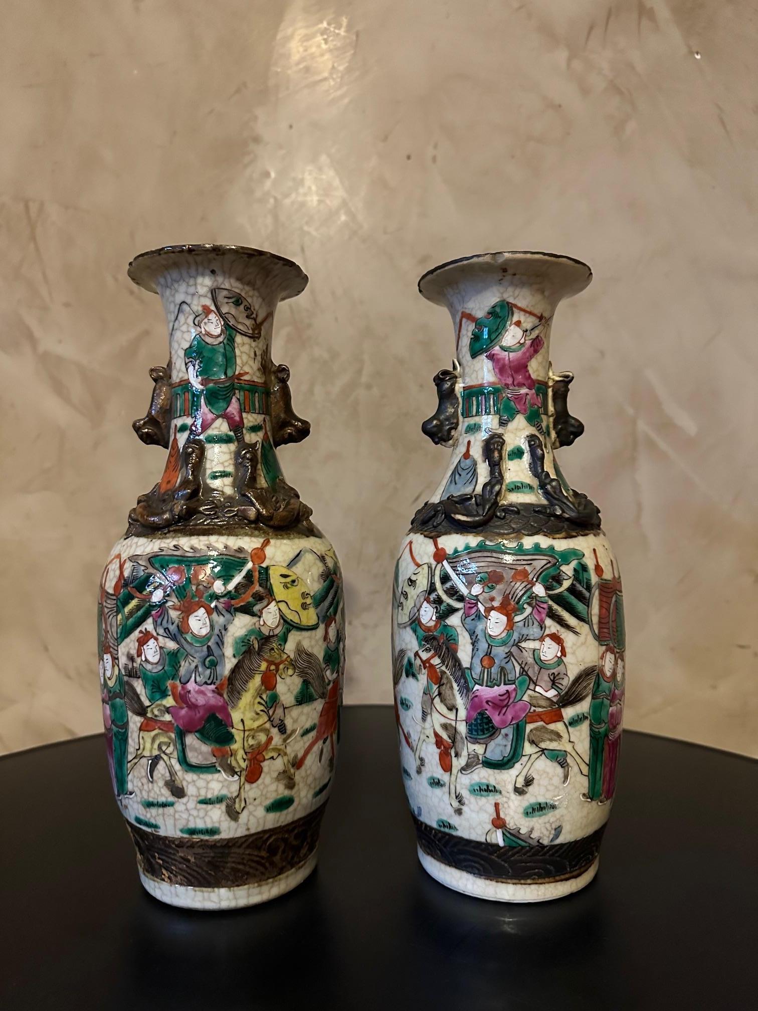 Very beautiful pair of 19th century Chinese vases in Nanjing porcelain. 
These vases feature a polychrome enameled decoration depicting battle scenes, soldiers armed with swords and spears. 
The edges are decorated with a collar decorated with