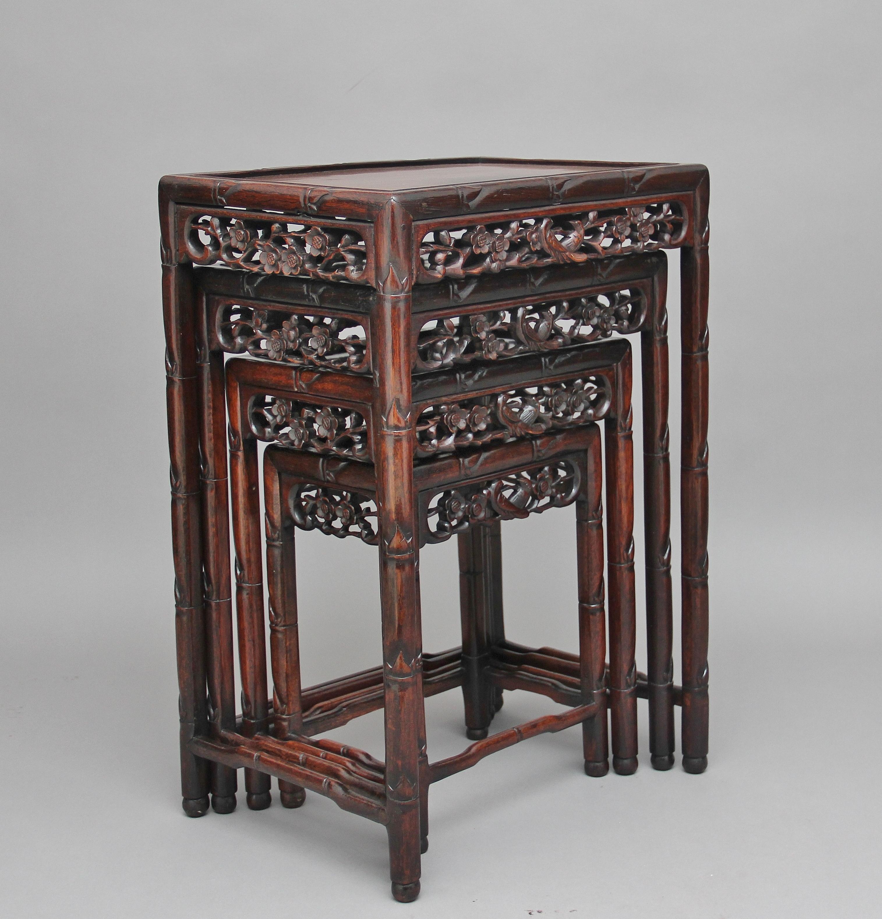 19th century Chinese hardwood nest of four tables, each rectangular top above a carved and pierced frieze of floral decoration, having turned legs united by a stretcher, circa 1880.
 
