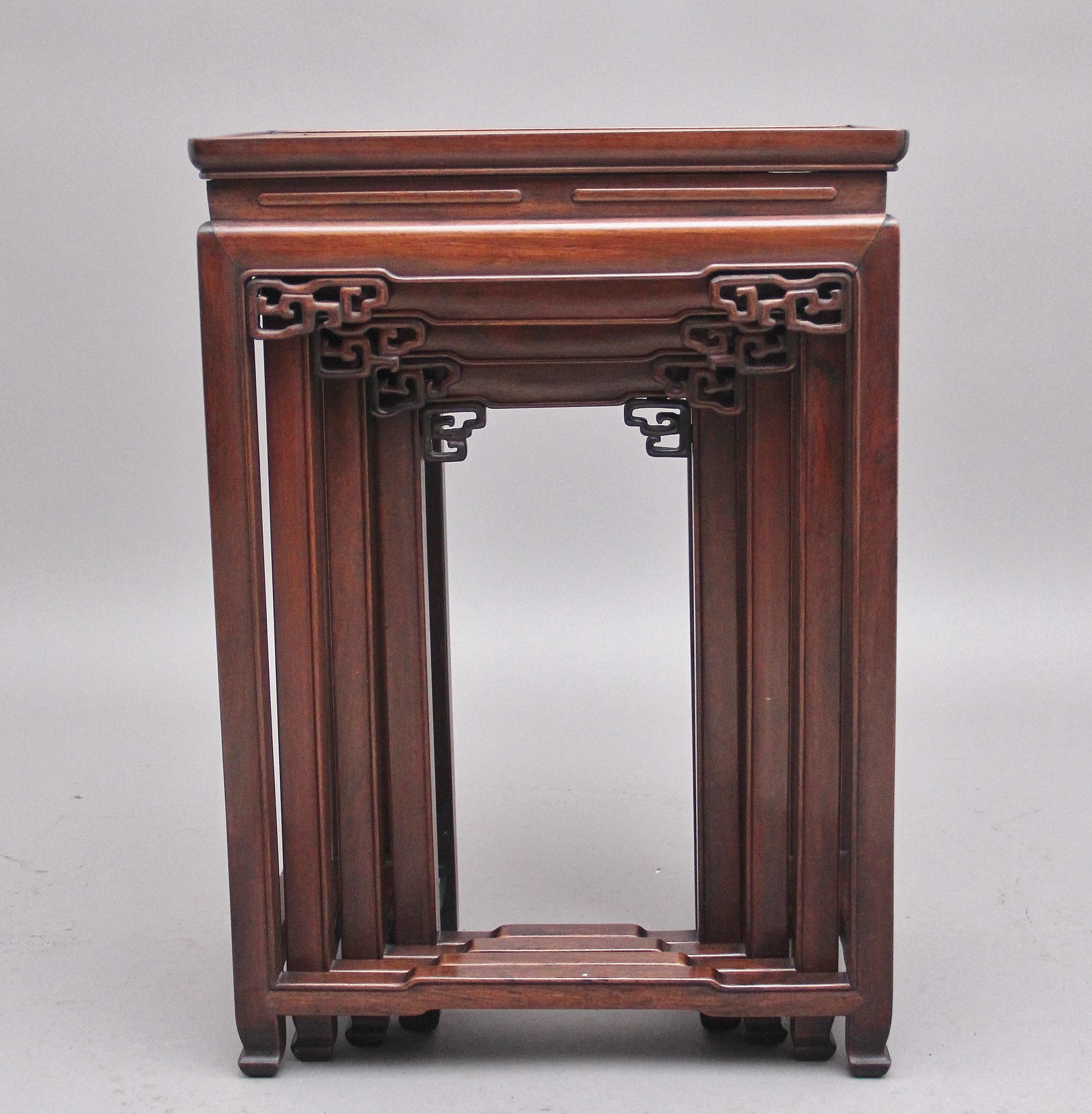 19th Century Chinese hardwood nest of four tables, having lovely figured moulded tops supported on pierced and carved square legs united by shaped stretchers, terminating on decorative carved scroll feet. Circa 1880.
 