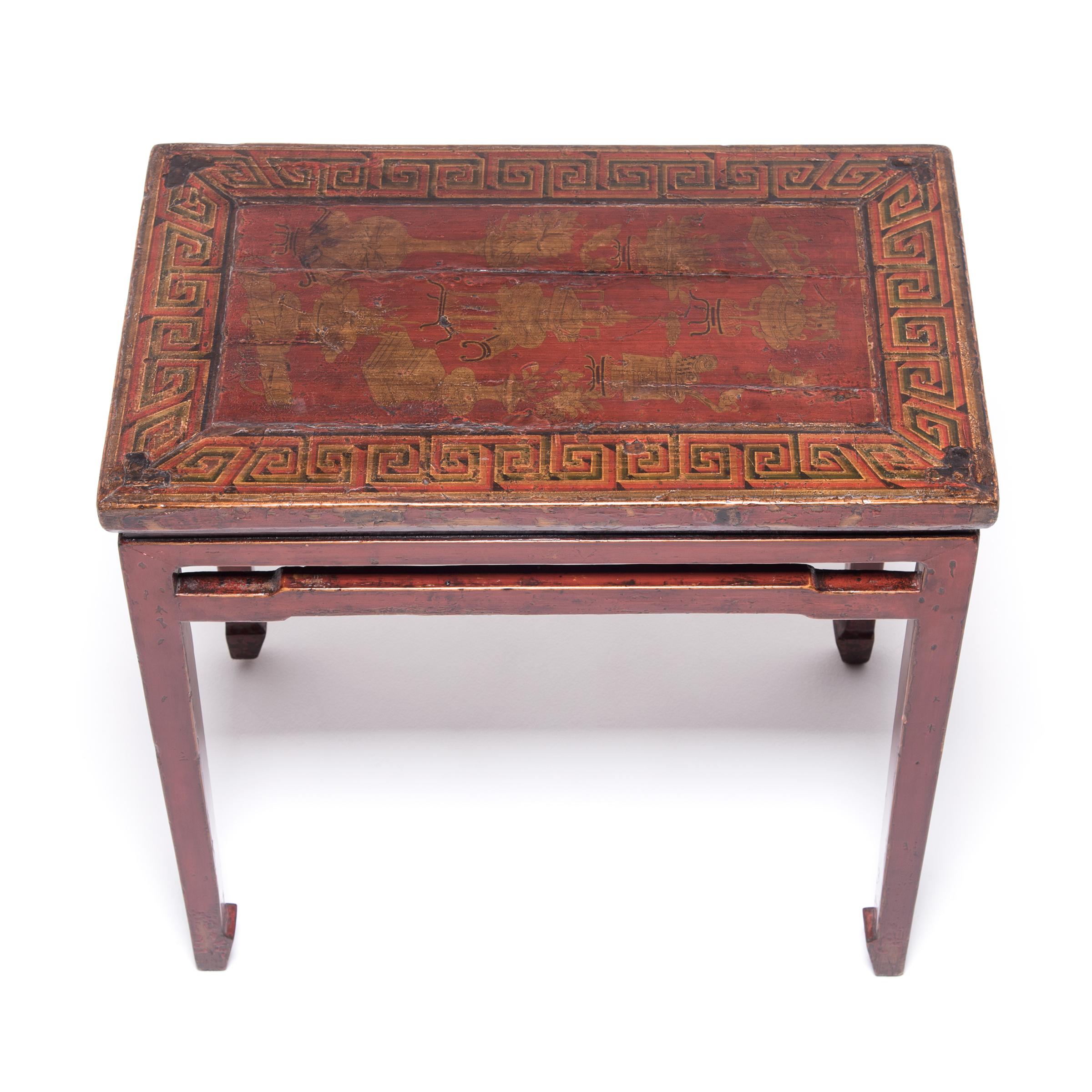 This mid-19th century console table was likely used as an offering table bearing incense. Appealing to the rarified taste of China’s literati, this Qing-dynasty table depicts auspicious objects found in a scholar’s studio. Atop the gorgeous red