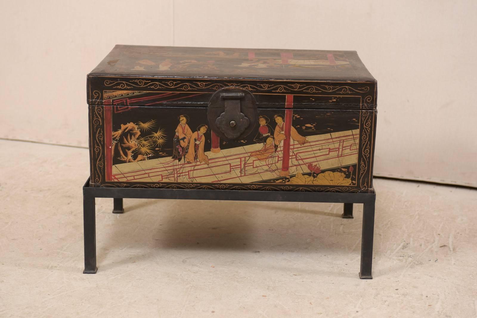 A turn-of-the-century Chinese painted leather covered chest on custom table base. This antique Chinese trunk, bound in leather, is beautifully adorn with hand-painted depictions of Chinese figures (mostly female) gathered in an outdoor setting about