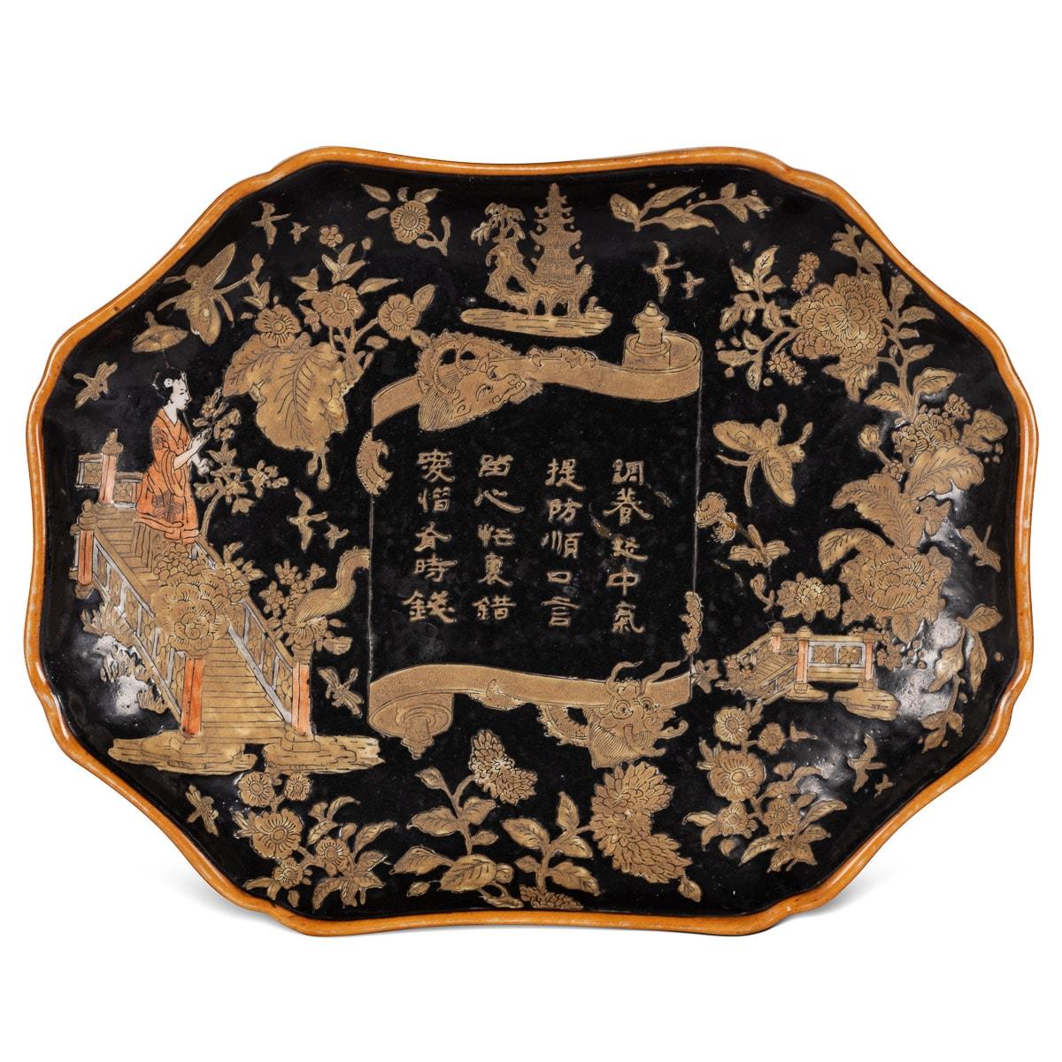 Antique 19th century Chinese pair of porcelain dishes hand painted in black polychrome enamel with traditional scenes, scrolls with emerging dragons, a pagoda along with a floral foliage surroundings. The center of the dish has an inscription in