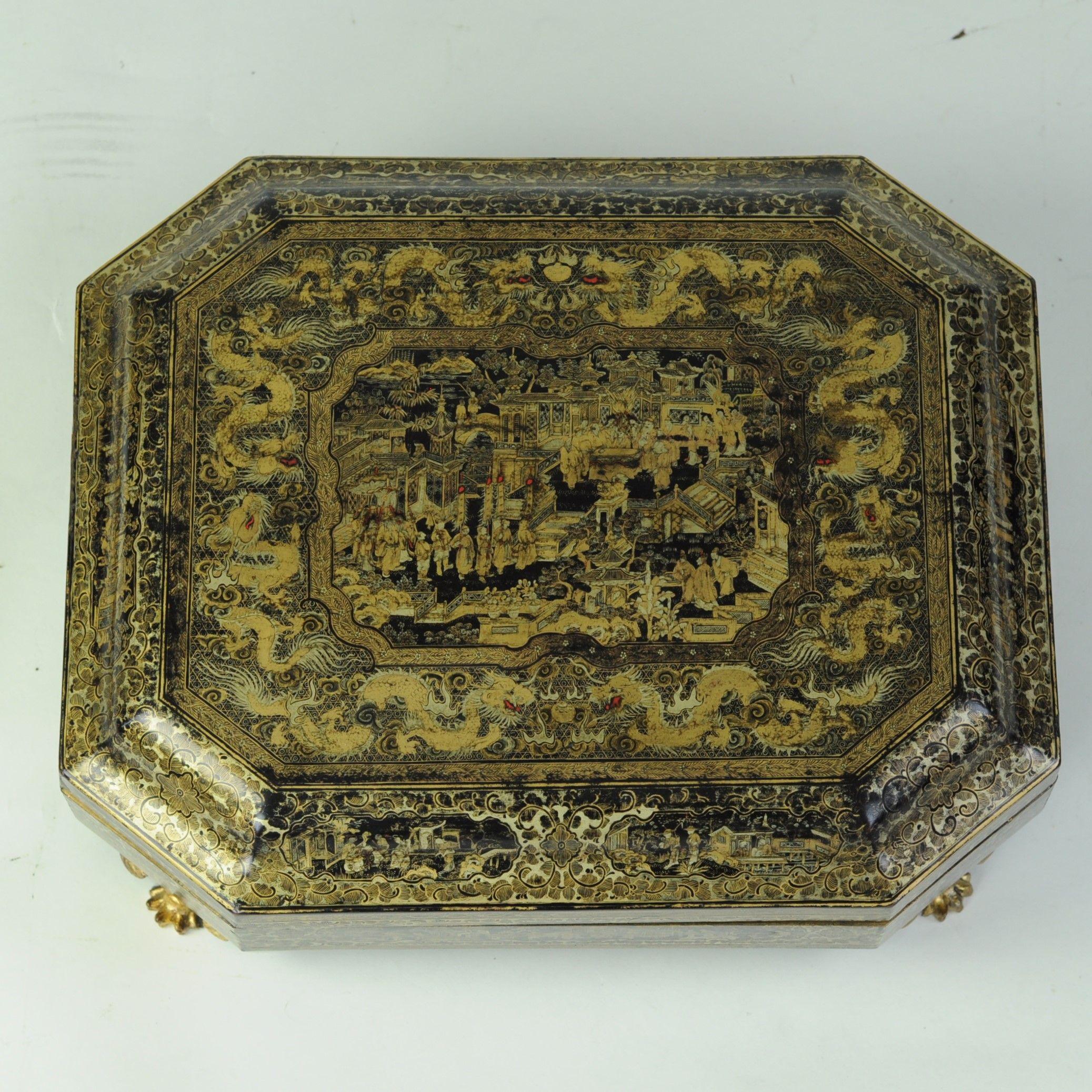 A rare and complete mid 19th century papier-mâché Games Box decorated with a central pen-work scene to the top depicting a gathering of Chinese figures on a terrace of a building surrounded by lush gardens with steps and terraces and further