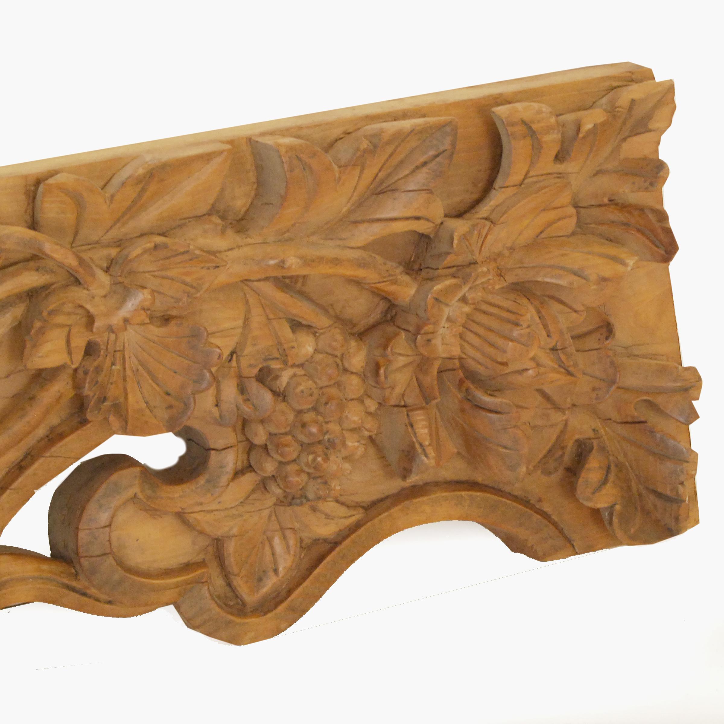 This architectural valance from the 19th century is beautifully carved in multiple dimensions with lotus, flora, and fruits on the vine and centered with a pearl of wisdom. It beautifully represents the masterful craftsmanship sought by 19th century