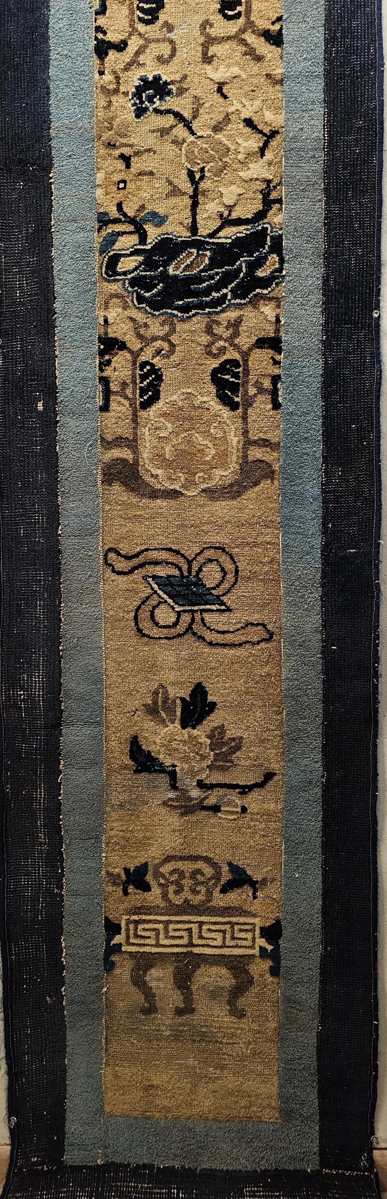 A vintage Chinese Peking narrow runner from the late 19th century in Ivory and blue colors. A number of traditional Chinese fortune symbols are set in a column in an ivory color field with two narrow borders in baby blue and navy. The Chinese Peking