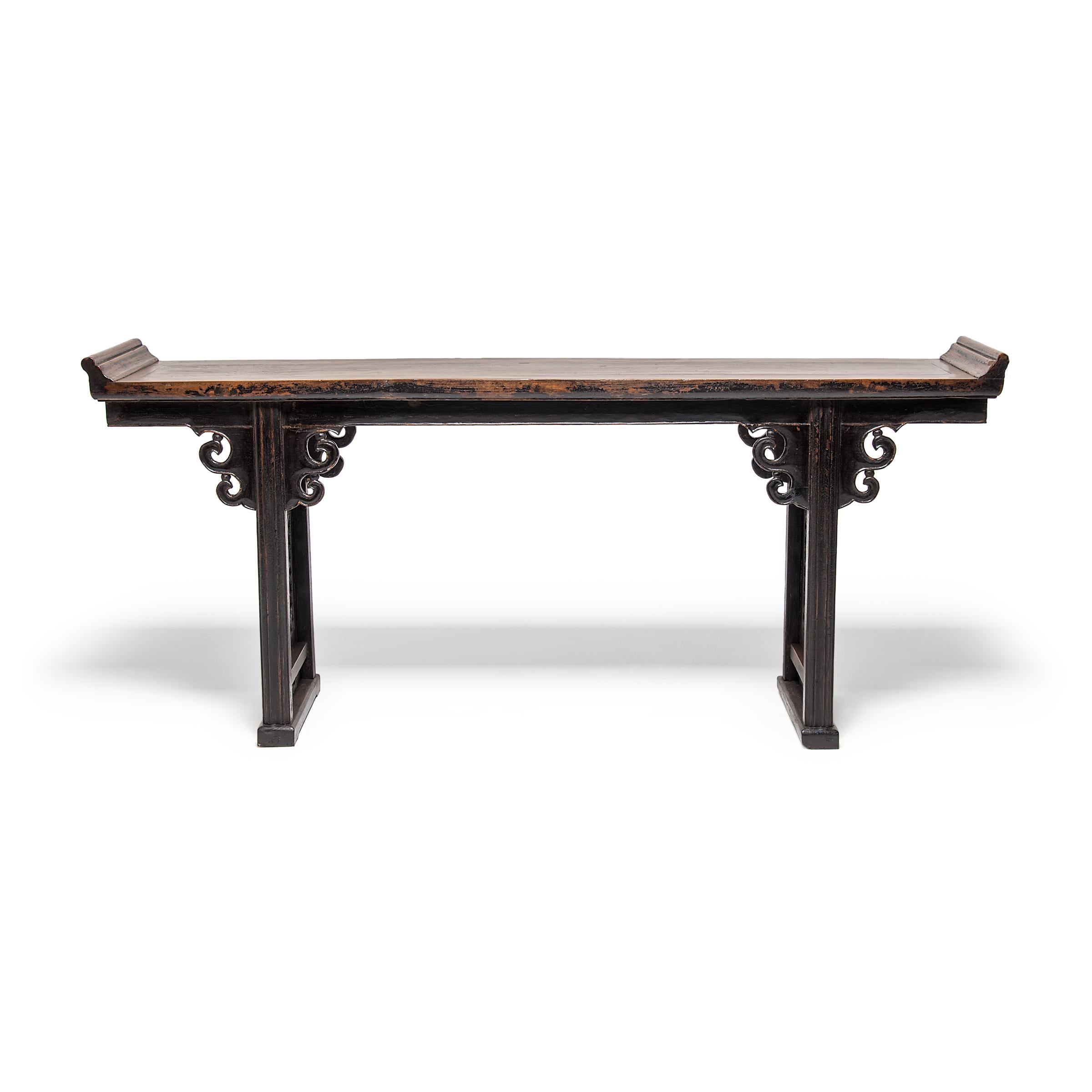 This impressive 19th century Asian altar table from northern China features cloud-form carved spandrels and beautiful lattice side panels. The curvilinear latticework is patterned to resemble delicate plum blossoms, common symbols of winter and