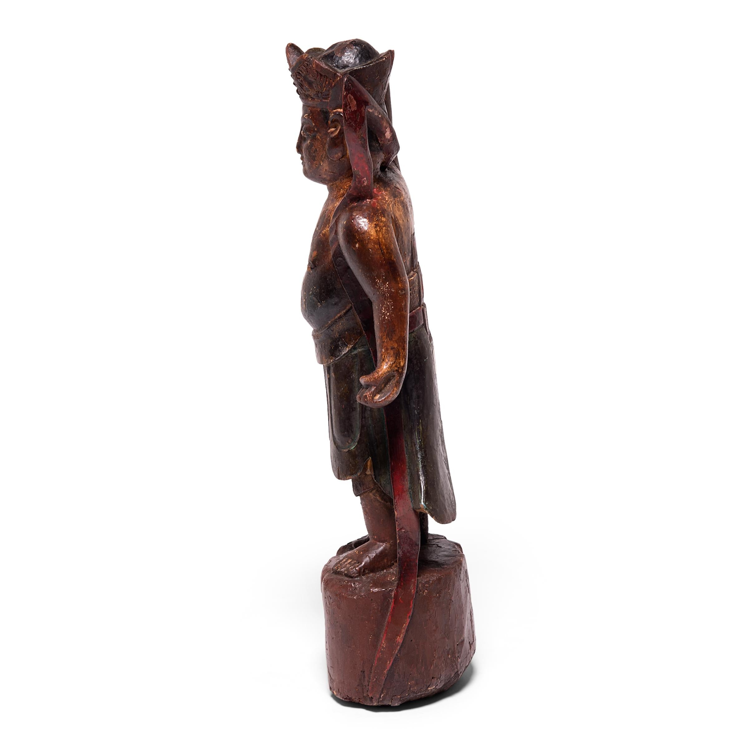 Hand carved and vibrantly painted, this 19th century figure of a mythical spirit was once placed upon a traditional altar table to pay tribute to ancestors past. The figure is carved with detailed robes, an elaborate hat, and long ribbon flowing