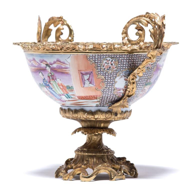 The exquisitely painted scene on this porcelain bowl is distinctly Eastern: the restrained, precise brushstrokes show a family lounging in a Chinese garden, surrounded by lush greenery and a scenic mountainous landscape. Made for export, the ornate