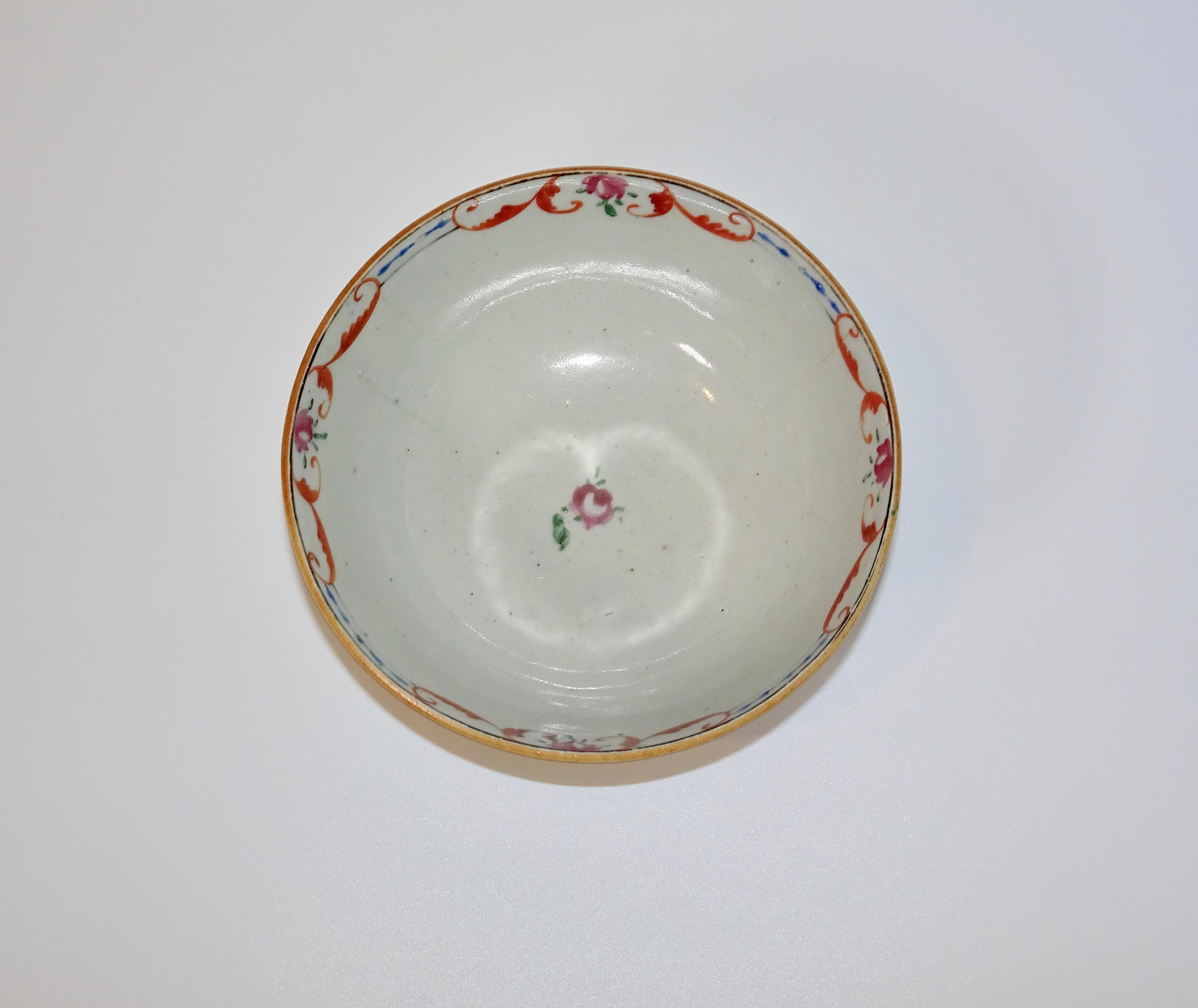 This is a 19th century Chinese export bowl in white. It has a decorative floral design in pinks, reds, and blues around the rim.