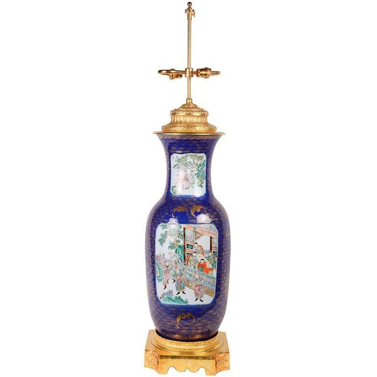 Vase/lampe de bonne qualité datant du 19ème siècle en bleu poudre et famille verte. Fond bleu foncé avec nuages dorés, chauve-souris et dragon. Les panneaux de famille verte représentant divers courtisans dans l'enceinte des temples et des jardins.