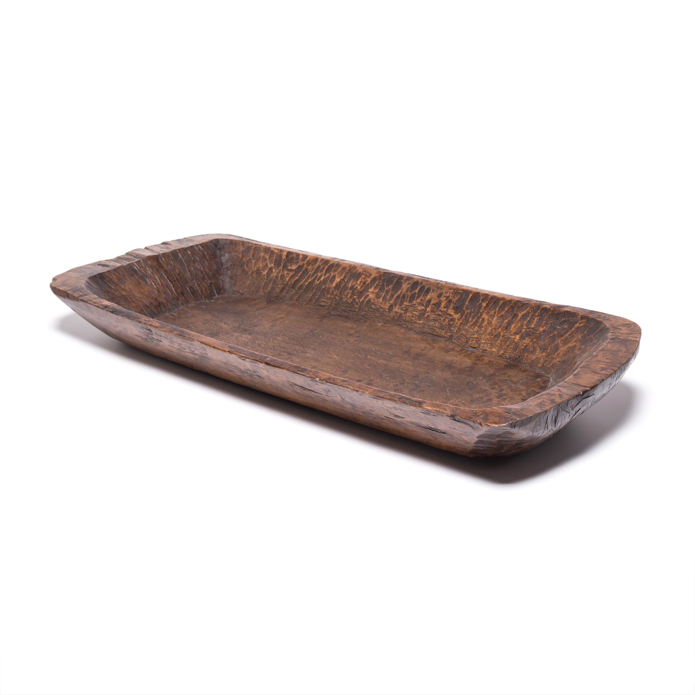 Carved from a single piece of northern Elmwood, this hundred year old butcher’s tray made in Shanxi province charms with its rusticity and organic form. Marked with use and distinguished by the natural grain and knots of wood, the rectangular tray