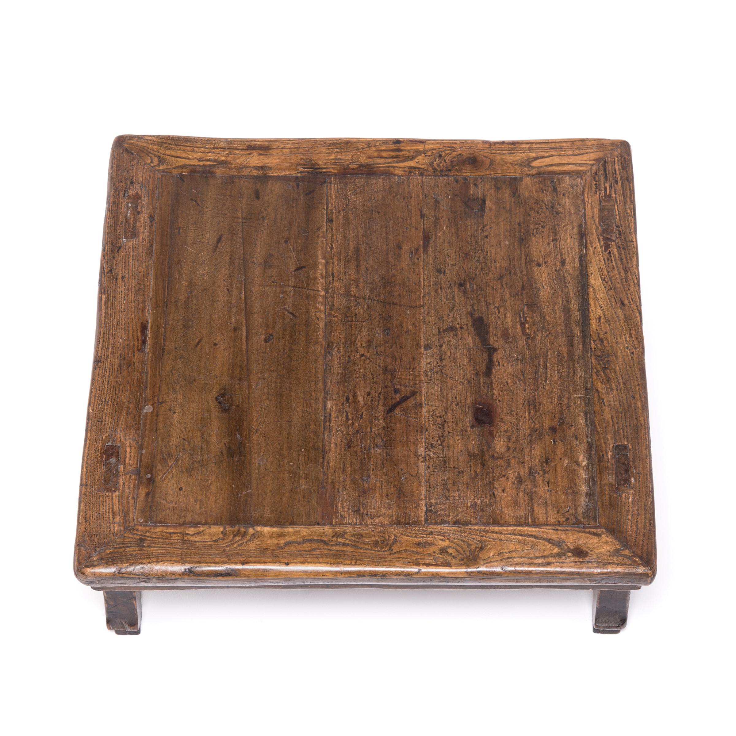 This lovely, low-profile table once served up wine, food, and board games to guests who sat or reclined on a platform or floor. Made of Chinese northern elmwood (yumu), the petite table is detailed with a carved scroll apron and charming hoof feet.