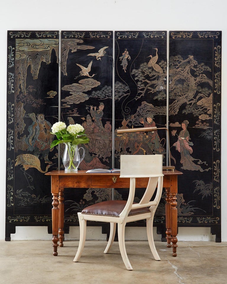 Stunning Mid-20th century Chinese four-panel Coromandel screen depicting Taoist eight immortals. The screen features lacquer incised panels with beautifully faded colors and a fine craquelure finish on the lacquer. The figural landscape is decorated