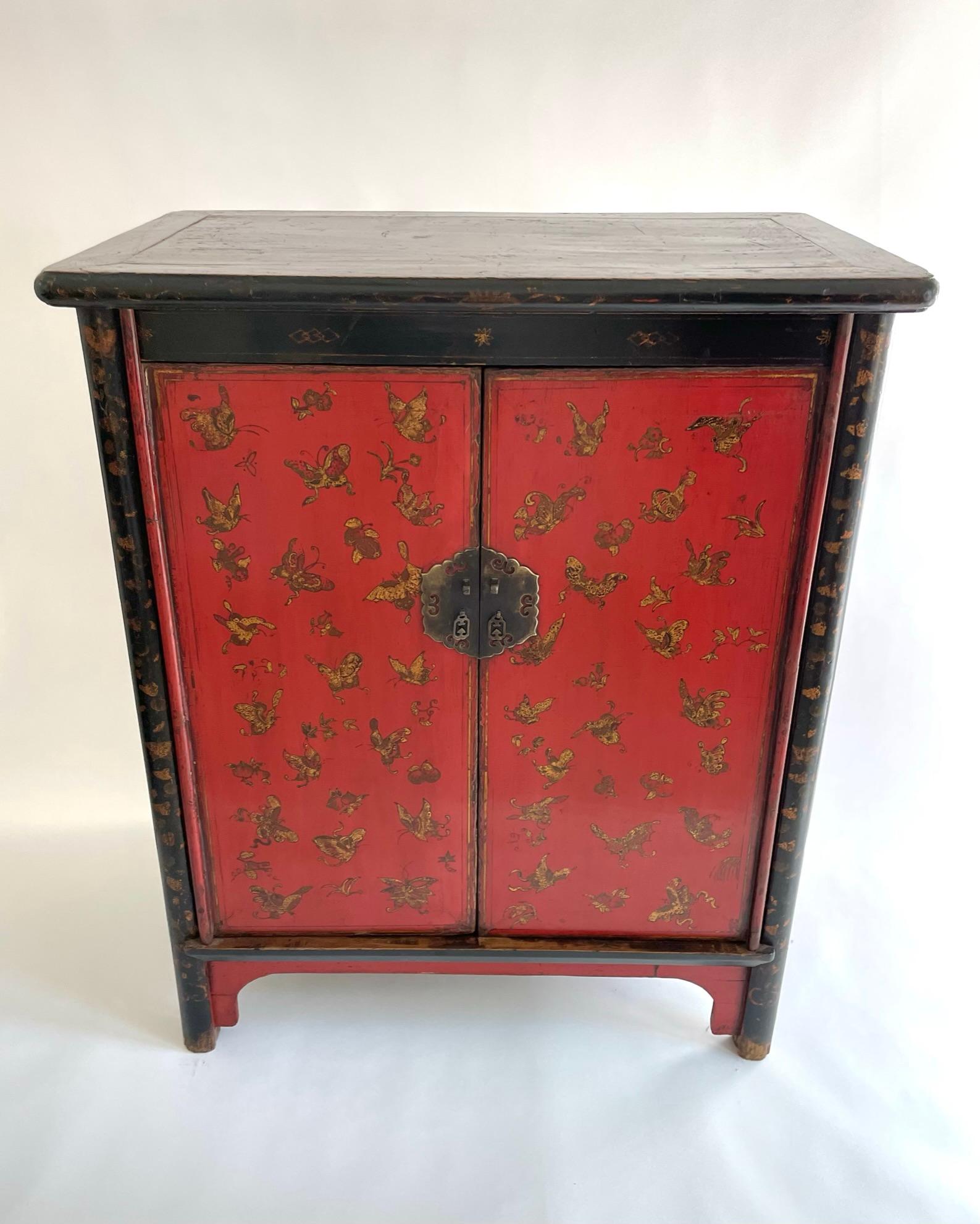 Beautifully painted Chinese red lacquered cabinet with gilded butterflies. Hand crafted and hand painted from the Shanxi province of north China during the early 18th century. The wood used is Yumu (northern elm). The butterflies are painted with