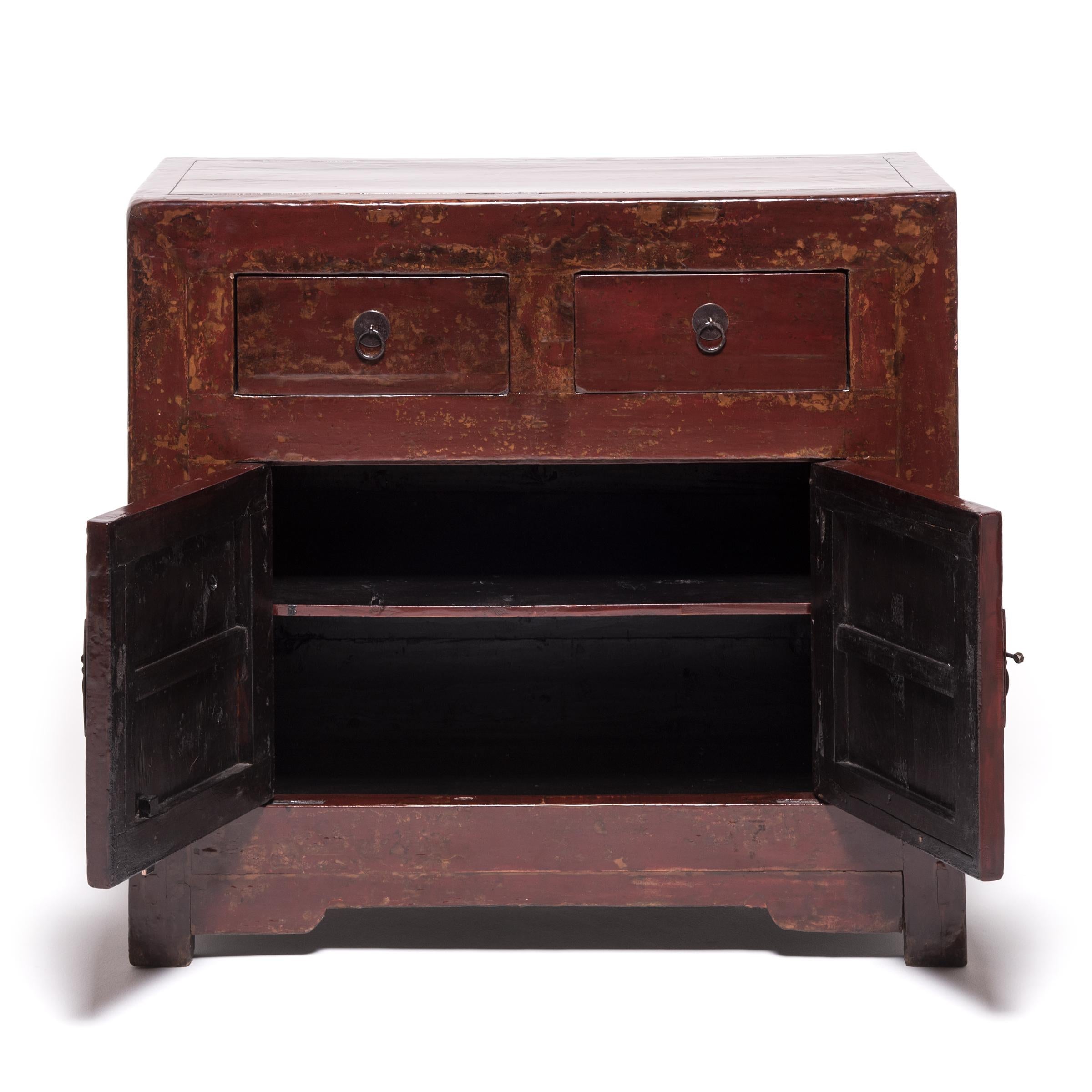 This 19th century chest, hailing out of northern China, started its life as a storage trunk with a solid lacquered front. Artisans, skilled in traditional Chinese carpentry and lacquer finishes, have reconfigured the trunk into a two-door chest,