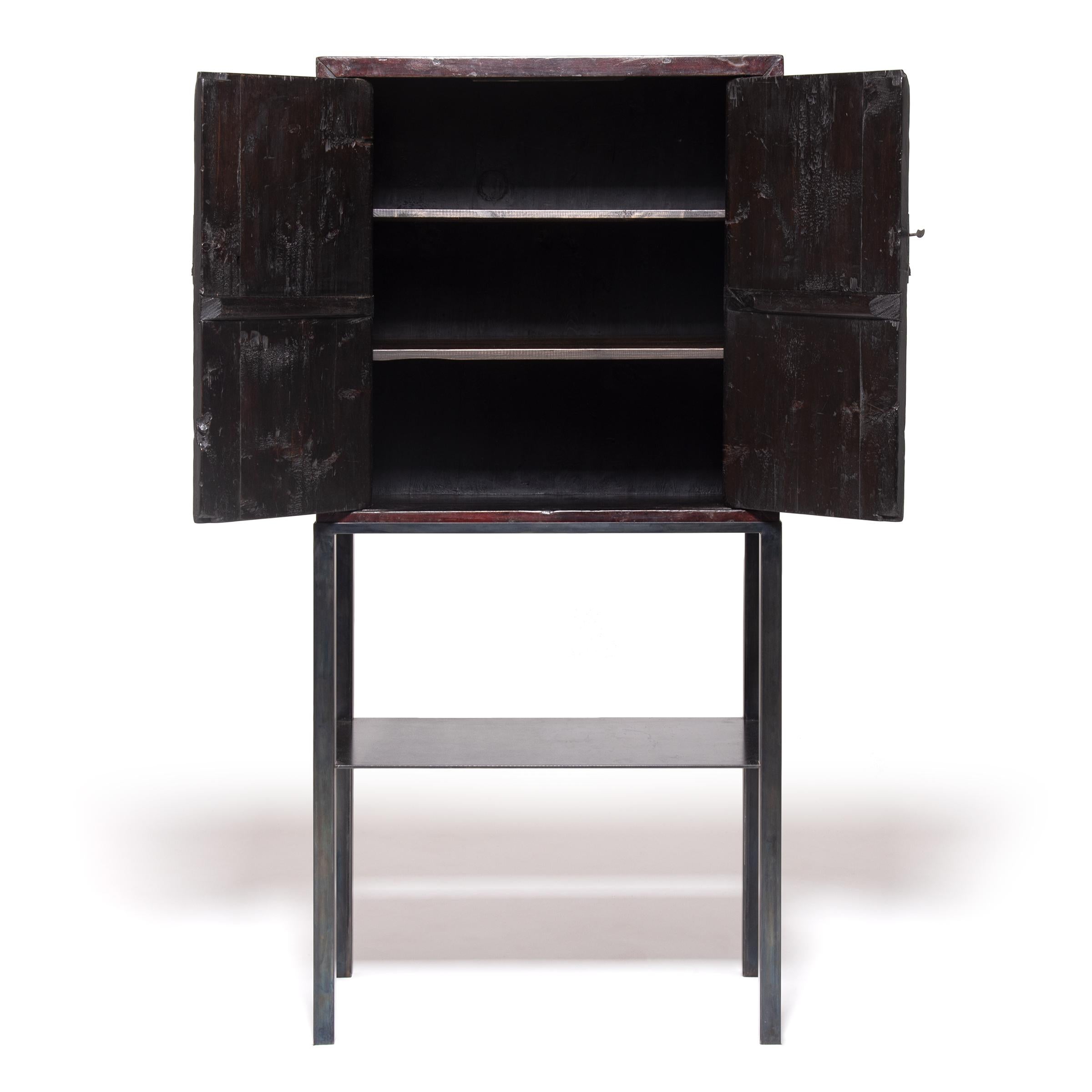 Perfect in line and proportion, this cabinet celebrates Minimalist design which was a gift from China to the world during the Ming period. The natural beauty and texture of wood comes through the surface of red lacquer, laboriously applied one layer