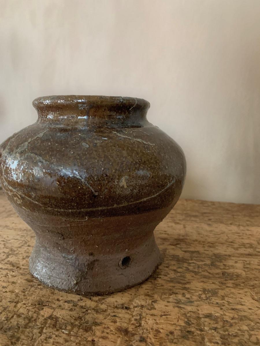 A 19th century rice pot from the Hunan region. The glazed ceramic pot irregularly decorated with an elegant baluster shape.