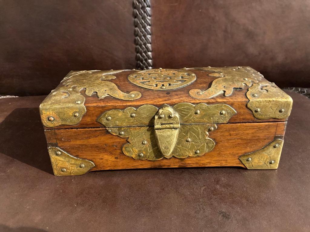 A fine Qing dynasty rosewood box with copper mounts and hinges. The central circular metalwork medallion on the top bracketed with wonderful stylized moths. The front escutcheon also in the form of a moth. The patina on both the copper and the