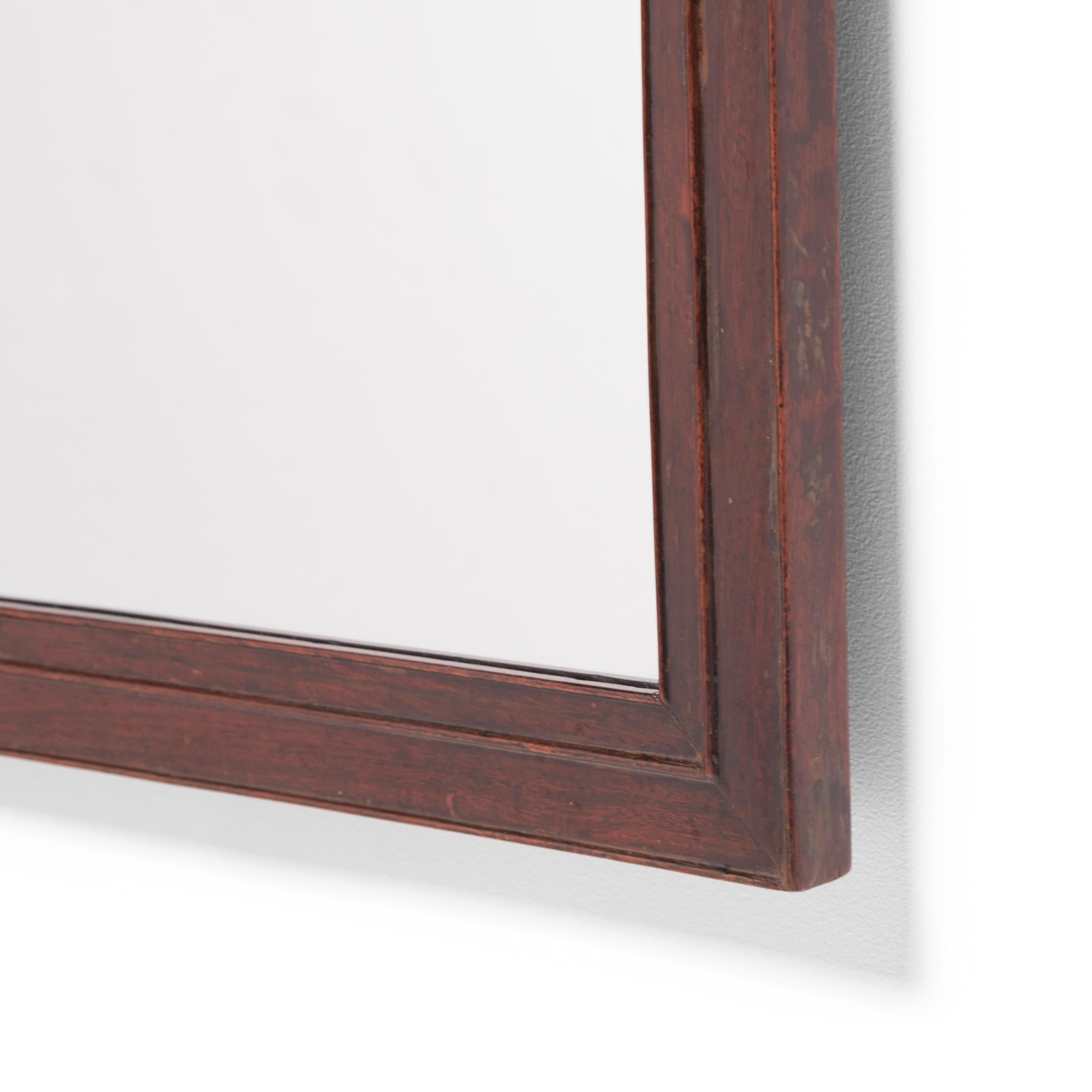 Dieser chinesische Gelehrtenspiegel aus der Mitte des 19. Jahrhunderts ist aus einem feinen Hartholz mit warmer Färbung und dichter Maserung gefertigt. Die Ecken sind auf Gehrung geschnitten und der Rahmen ist rundum mit drei dünnen Wulsträndern