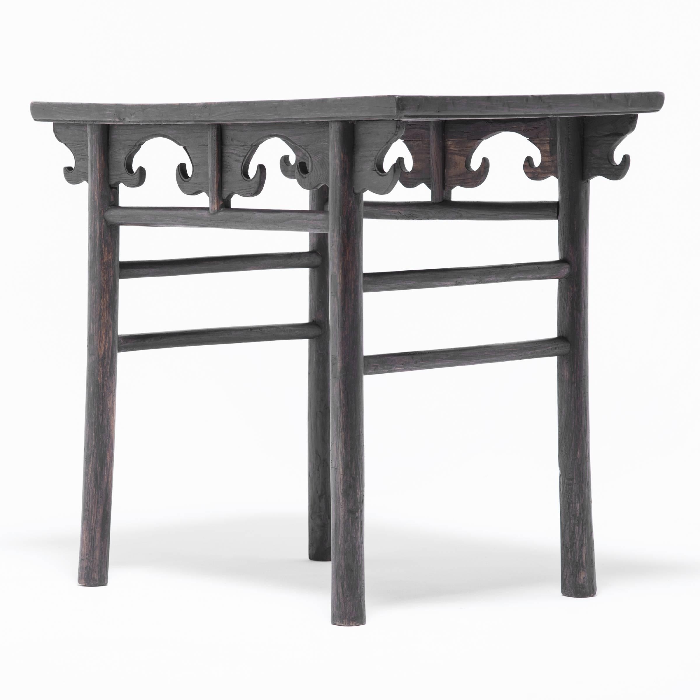 This exquisitely crafted elmwood table was made over 150 years ago in the Shanxi region of China. The simple and sophisticated construction is dramatically highlighted by the way the spandrels come together with the spirited apron motif to create a