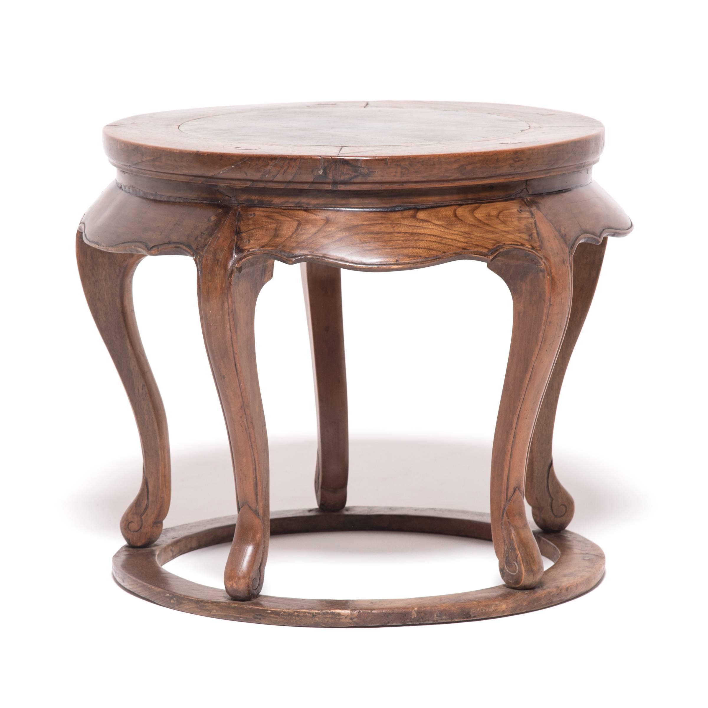 Honoring the essential character of wood and stone, this 19th century end table marries the animated grain of northern elmwood to the subtle veining of pure marble. A masterful design united by flowing curves, this table exhibits a flawlessly turned