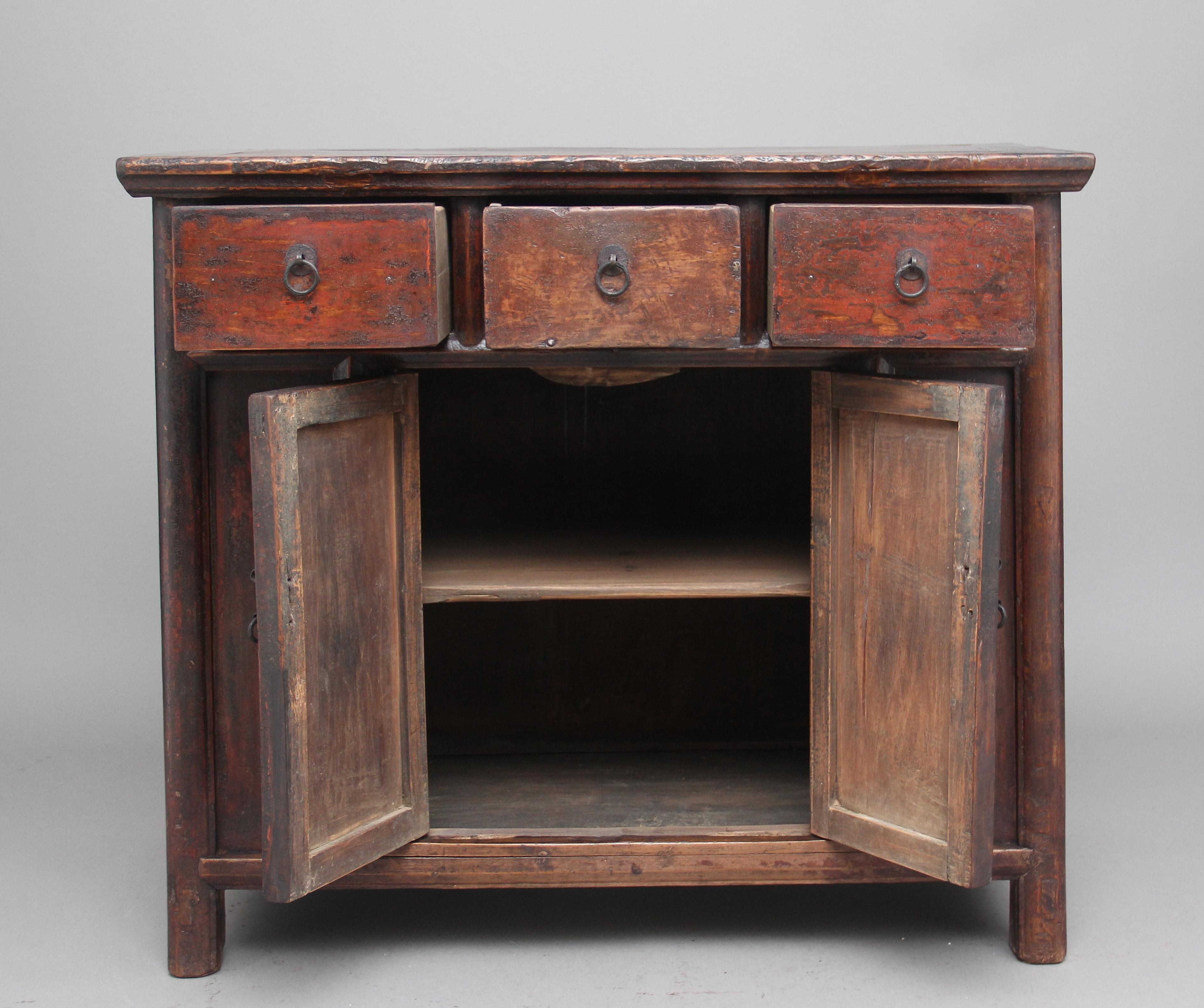 19th century Chinese rustic elm dresser, having three drawers above a two door cupboard opening to reveal a fixed single shelf inside, the drawers and doors having original brass ring pull handles, nice rustic mouldings, the cabinet having the