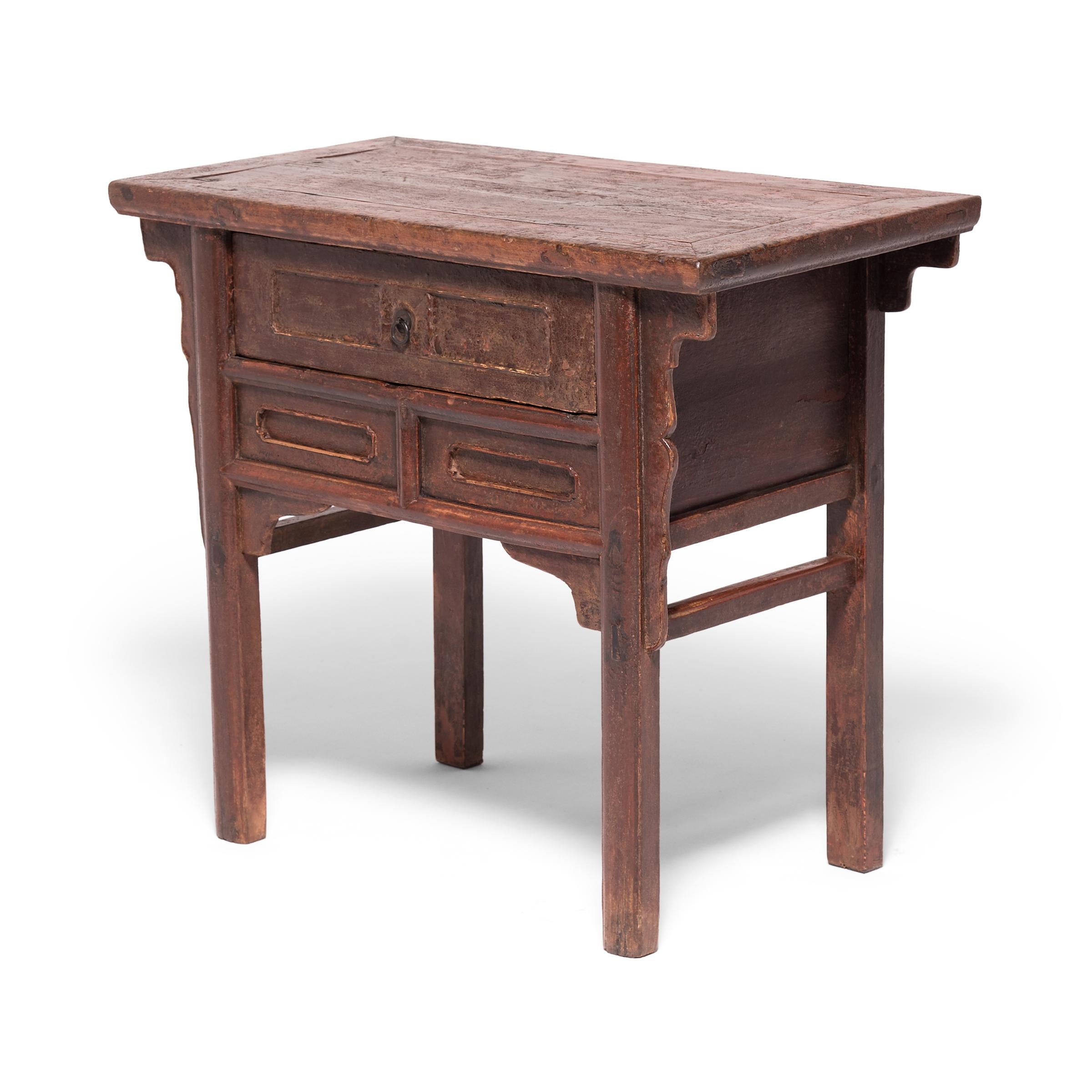 Crafted of northern elmwood in China's Shanxi province, this 19th century provincial table chest mixes simple Qing-dynasty forms with subtle ornamentation. Featuring a floating panel top and a single drawer with brass pulls, the table has a rustic