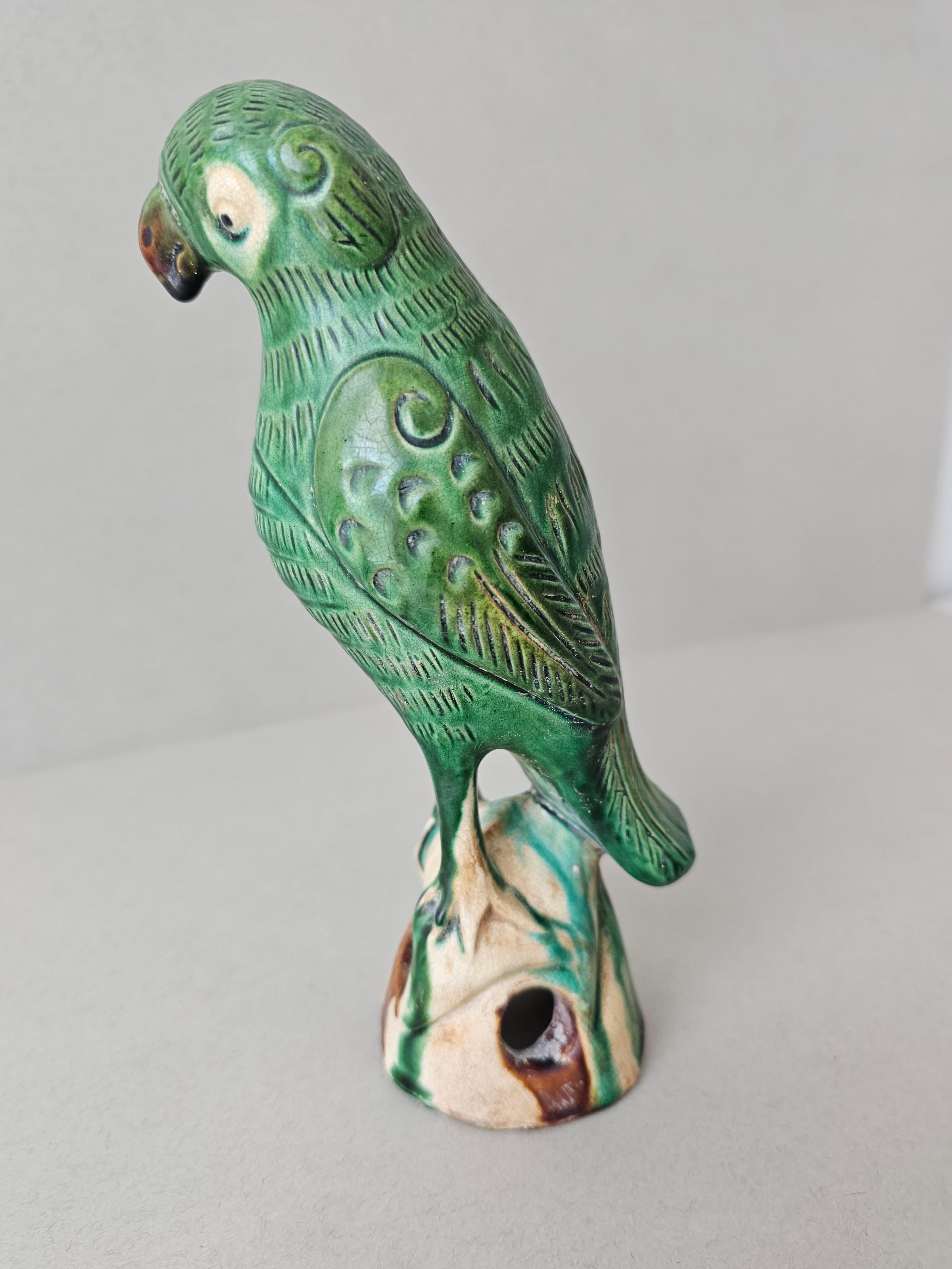 A charming Qing Dynasty (1636-1912) Chinese Sancai glazed pottery bird incense burner, 19th century, China, figural parrot form statue standing on rocky splash-glazed pierced base, small hole in back intended to hold incense stick. 

A wonderful