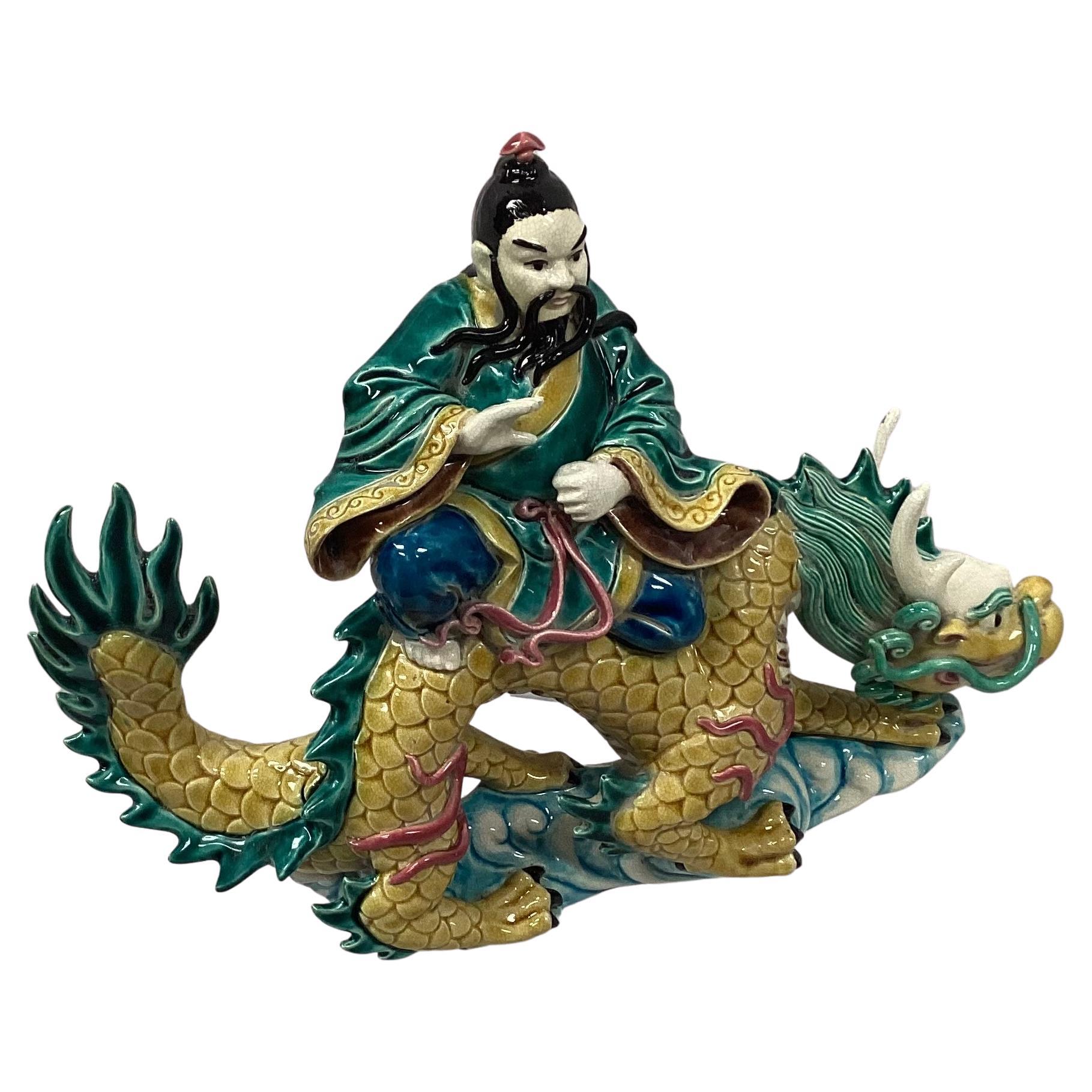 19th century Chinese Sancai roof tile. This piece is hand glazed and the painted tile is of pottery, depicting a warrior riding a large mythical dragon serpent. Beautiful colors of yellow, green, blue and pink. It is presented mounted on a Lucite
