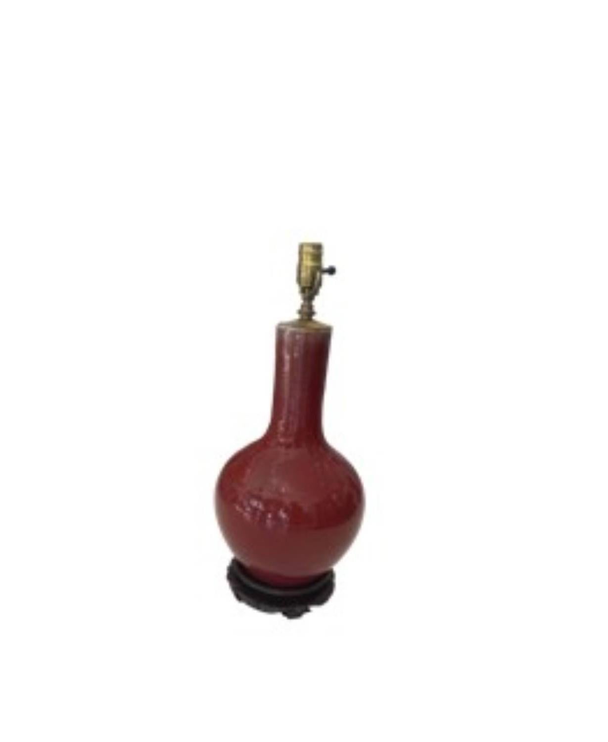 The deep, rich, orange/red color of this 19th Century Chinese “Sang Boeuf” ceramic lamp on its wood stand adds rich depth to any room or space! 
The Sang Boeuf (also spelled 