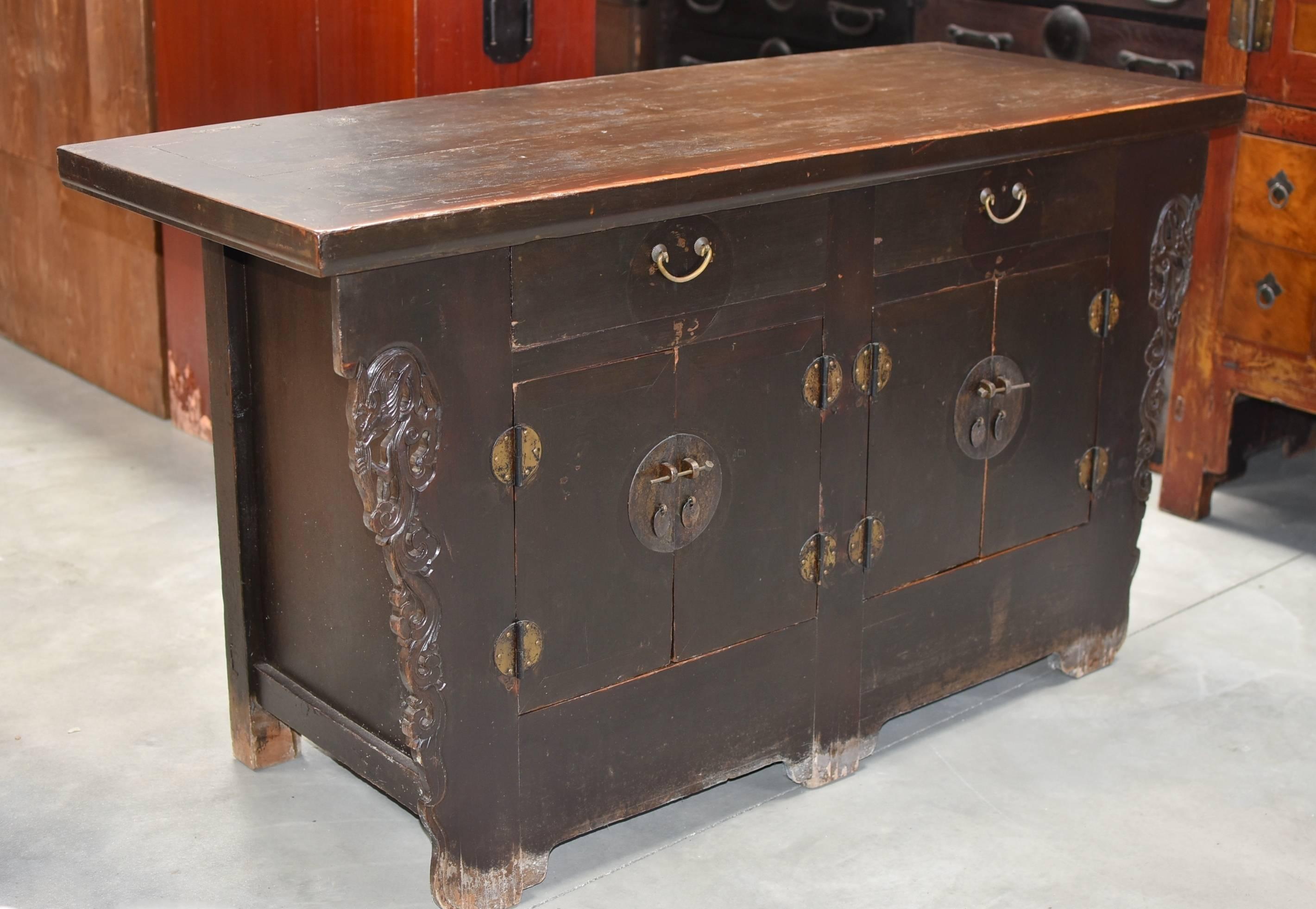 Beautiful 19th century sideboard from northern China. Solid wood construction with carvings of stylized dragons on the sides. Original top in excellent condition has beautiful patina. Drawers and internal shelves provide ample storage. A great piece