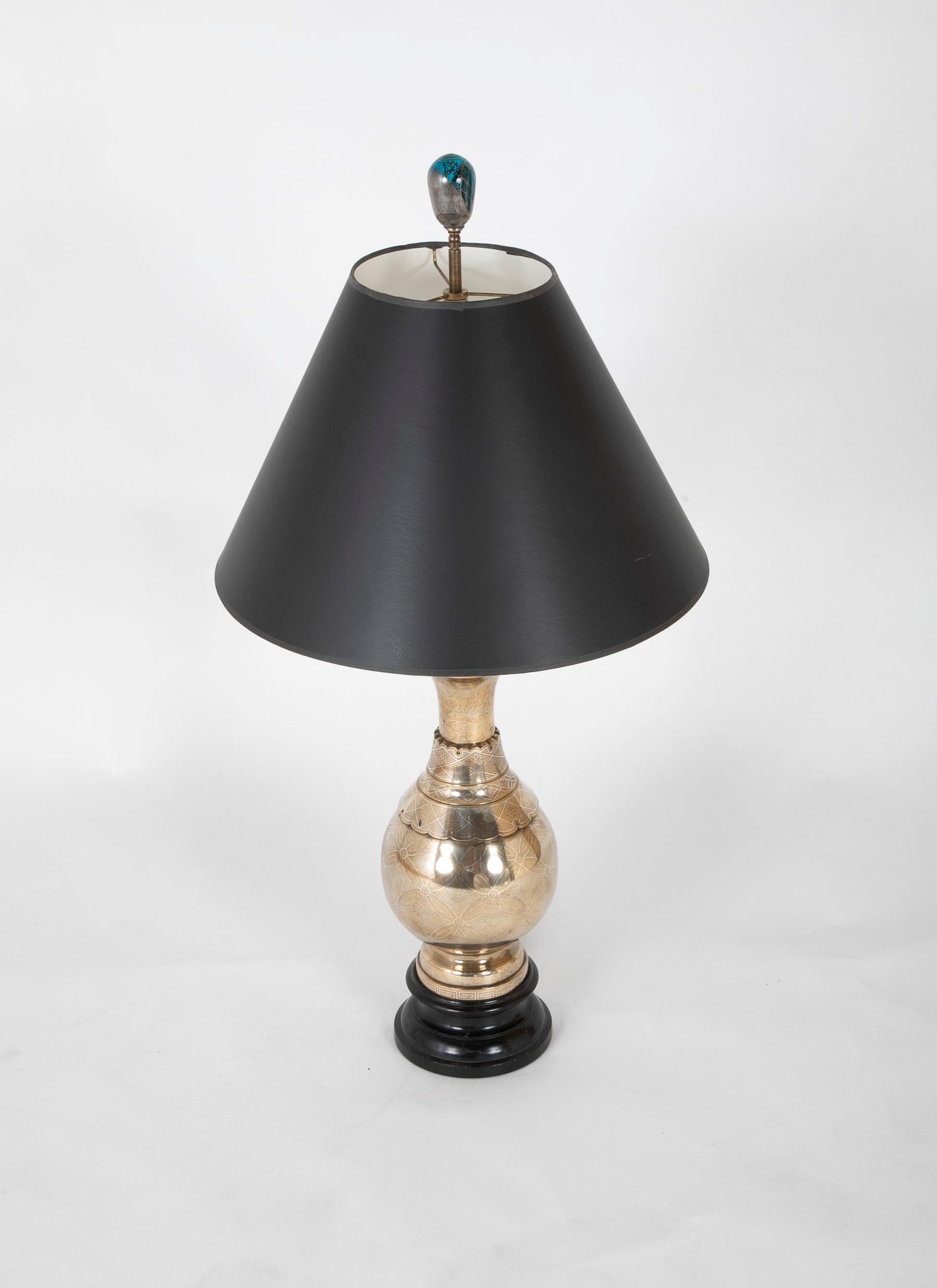 The bronze urn with delicate floral and 'Greek key' silver inlay covering the surface, mounted on a ebonized wooden socle base. Made with superior craftsmanship, the profile of this lamp is exquisite. The hand-blownn glass finial is included, the