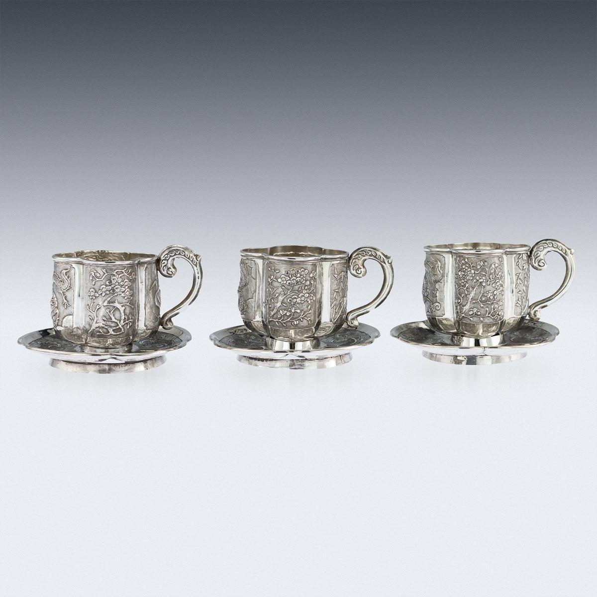 Antique late 19th century Chinese solid silver set of three tea cups and saucers, handcrafted and intricately engraved with dragon, cherry blossom, bamboo and applied shaped handles. Saucers hallmarked with Chinese character marks (acid tested shows