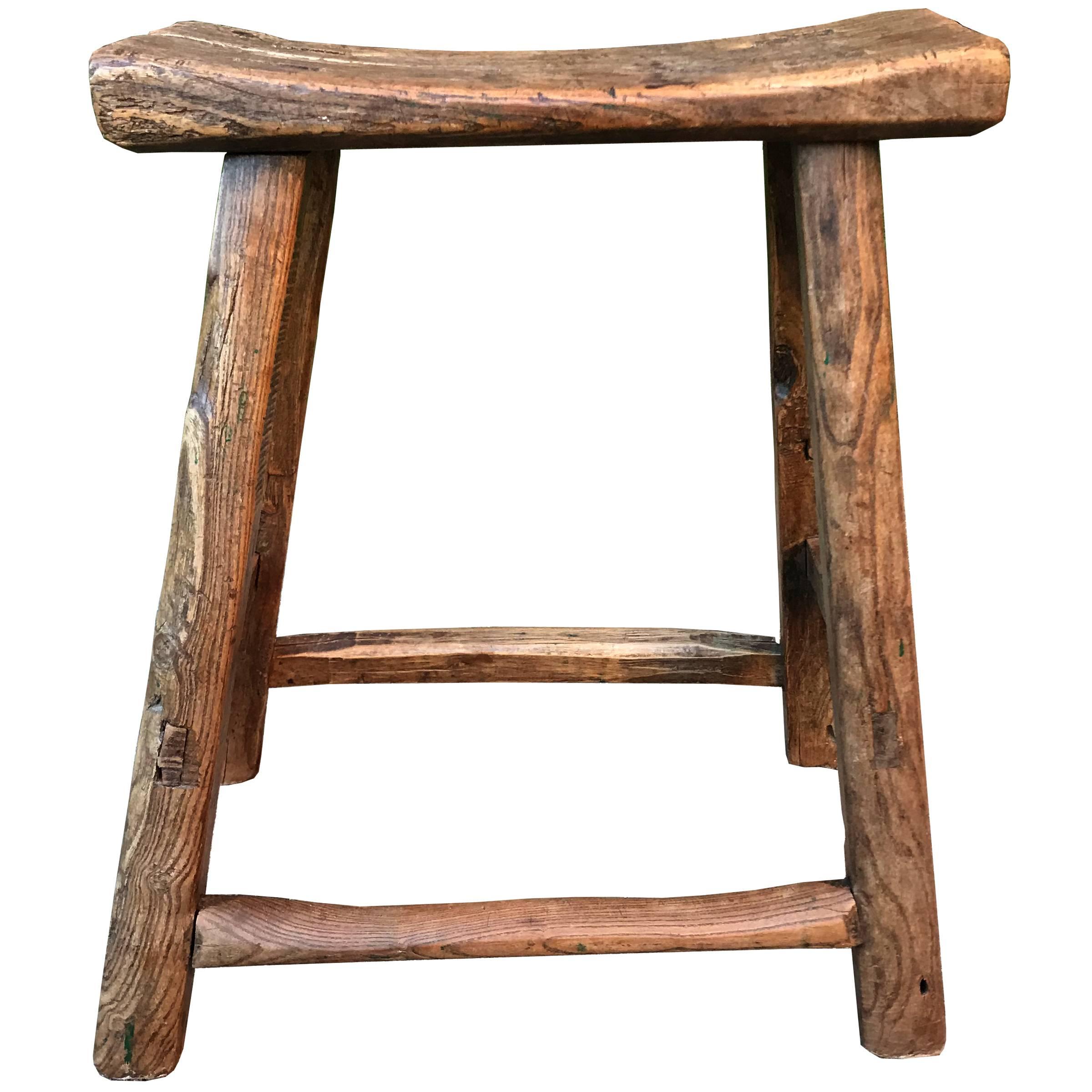 A 19th century Chinese fisherman's stool with a wonderful curved seat with tapered legs, and well worn stretchers. The top shows a century's use as a cutting board.