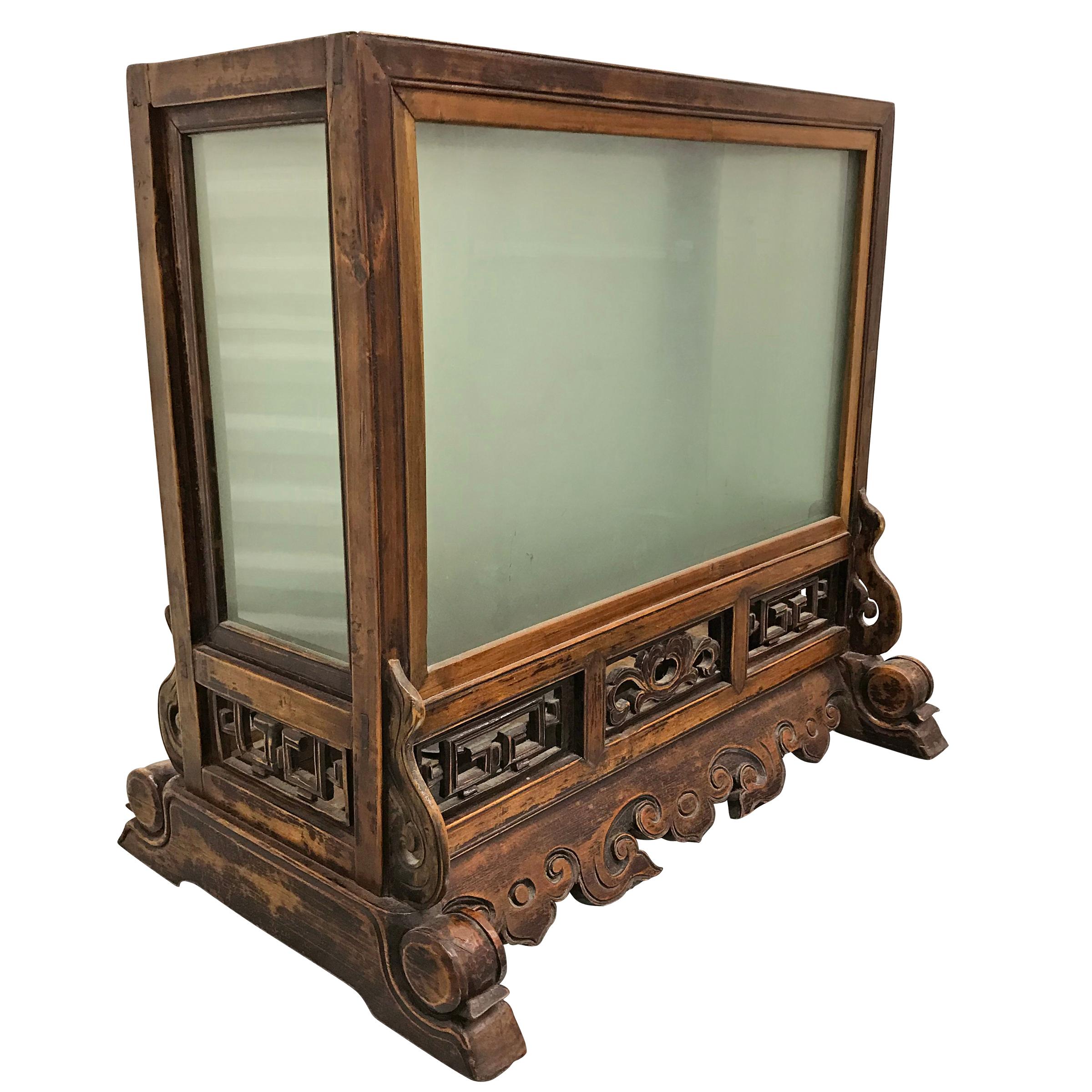 A 19th Century Chinese carved elmwood table lantern with floral carved apron, and platforms for three candles inside. The lantern would have originally had silk sides, but has been updated with frosted glass panels.