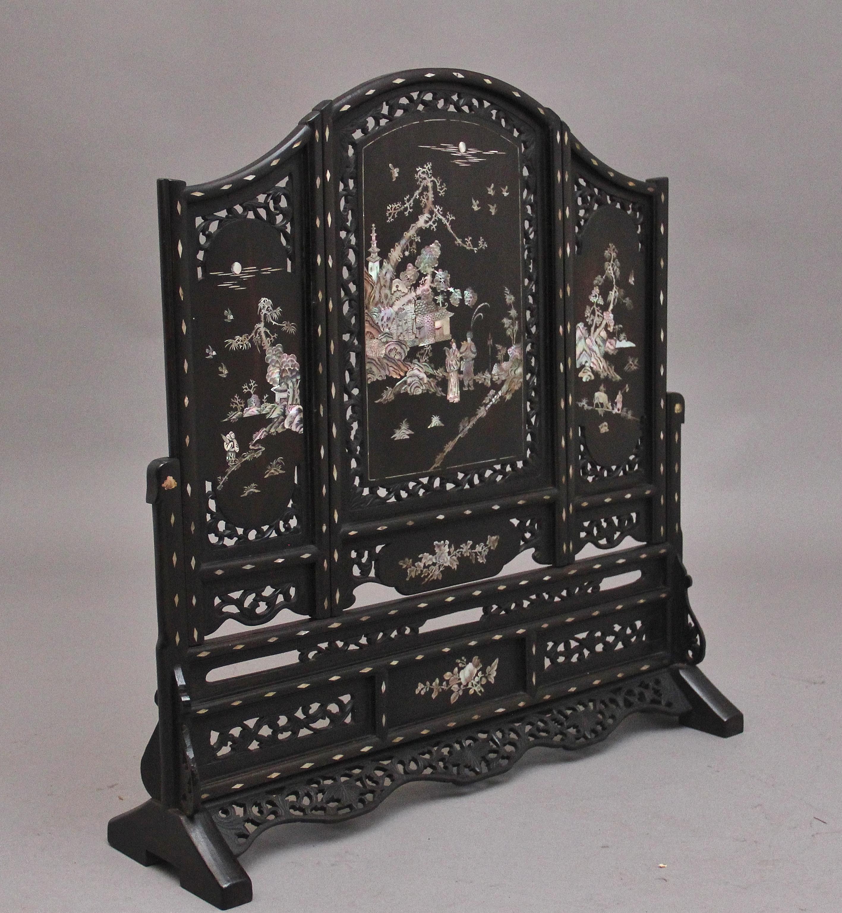 Écran de table très décoratif en bois dur chinois du XIXe siècle, composé de trois panneaux en forme, chaque panneau présentant des incrustations florales percées et sculptées et des incrustations de nacre représentant une scène de campagne