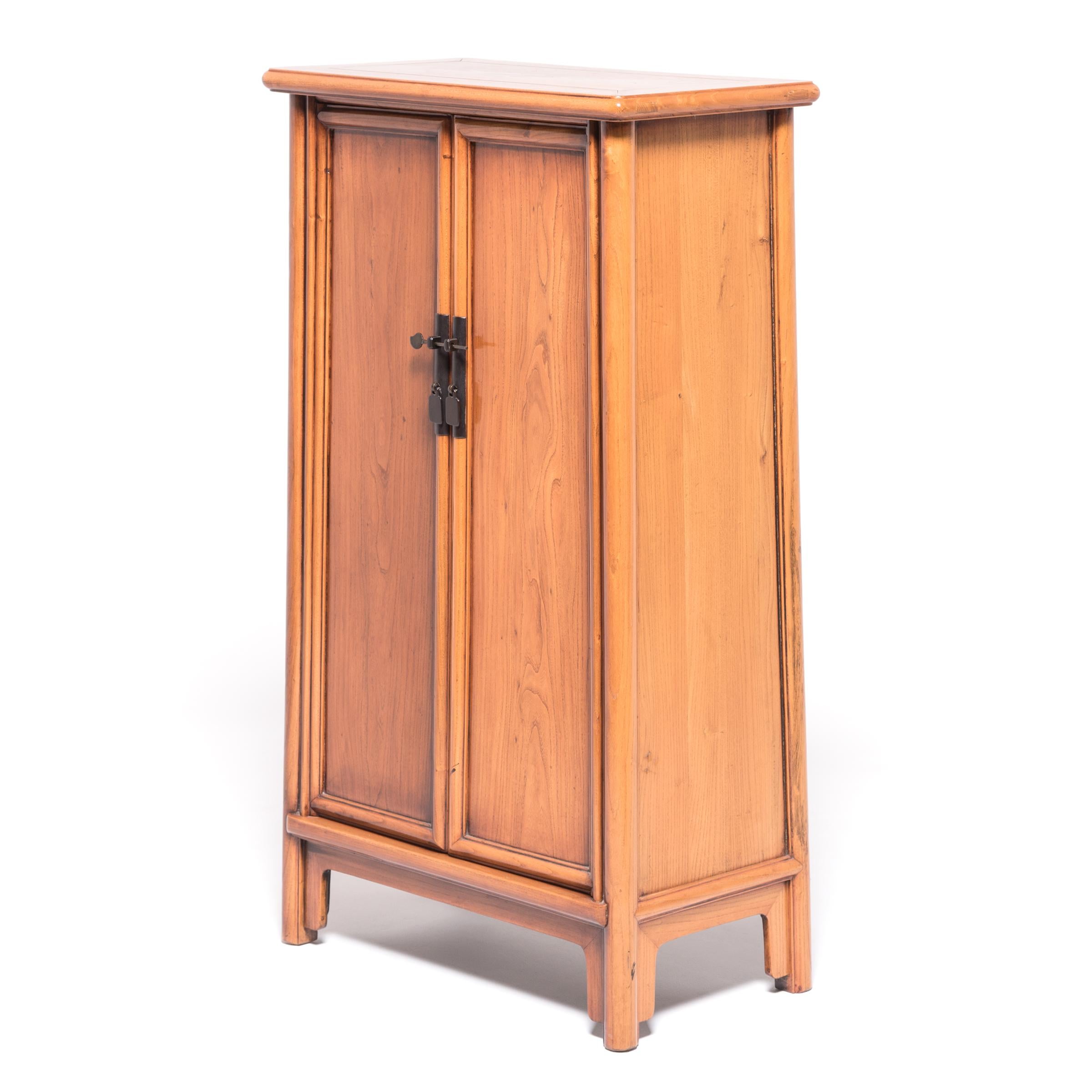 A Classic piece of Chinese furniture, this 19th century elmwood cabinet embodies the simple and subtle elegance of Ming furniture. It probably once sat in a home in China’s Shanxi Province; its shelves filled with curios or embroidered silks. The