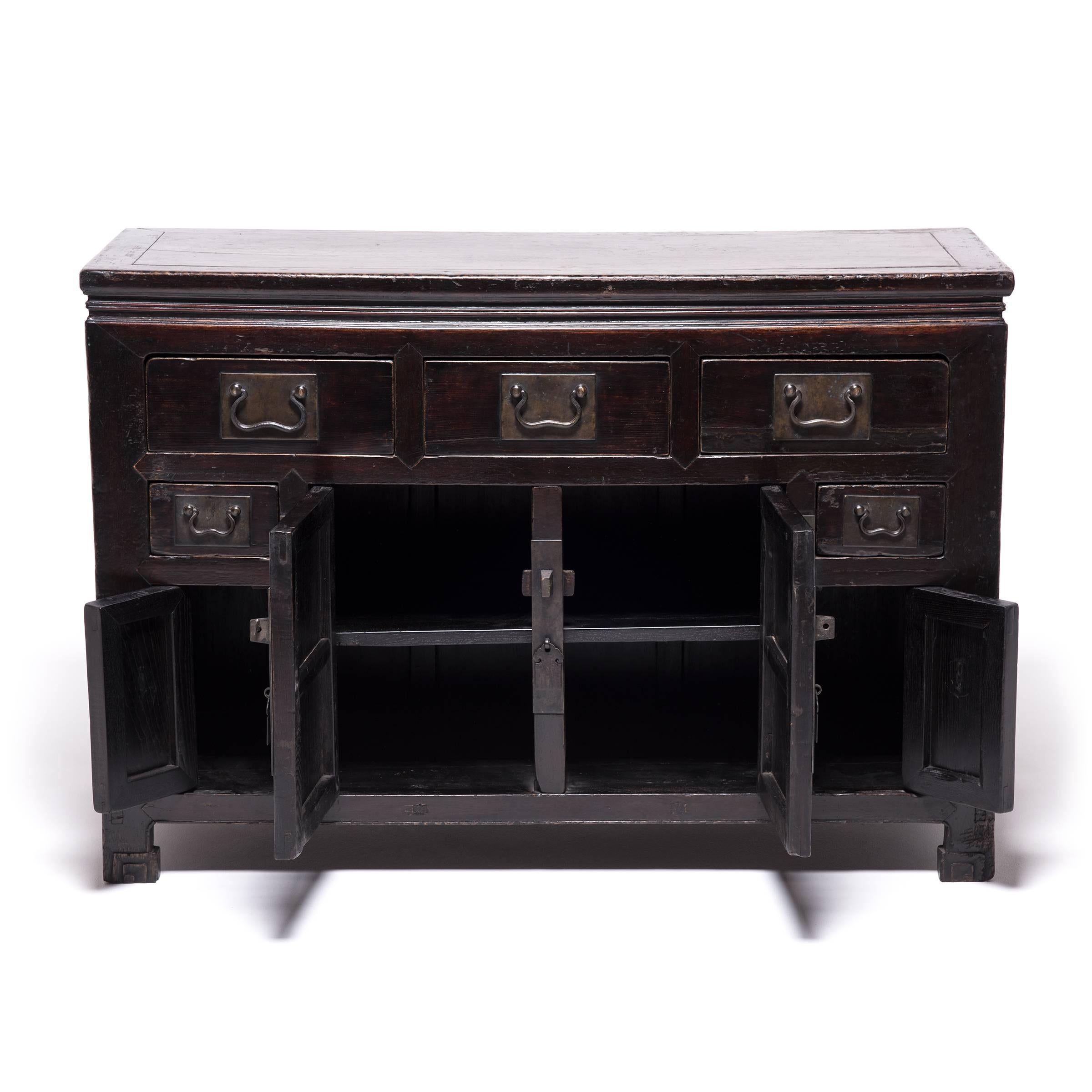 Made in Tianjin, a port city in Northern China, this 19th century coffer beautifully represents household storage cabinets of the era. The waist and apron are carved from a single piece of wood, its hoof feet are carved with scrolls, and it