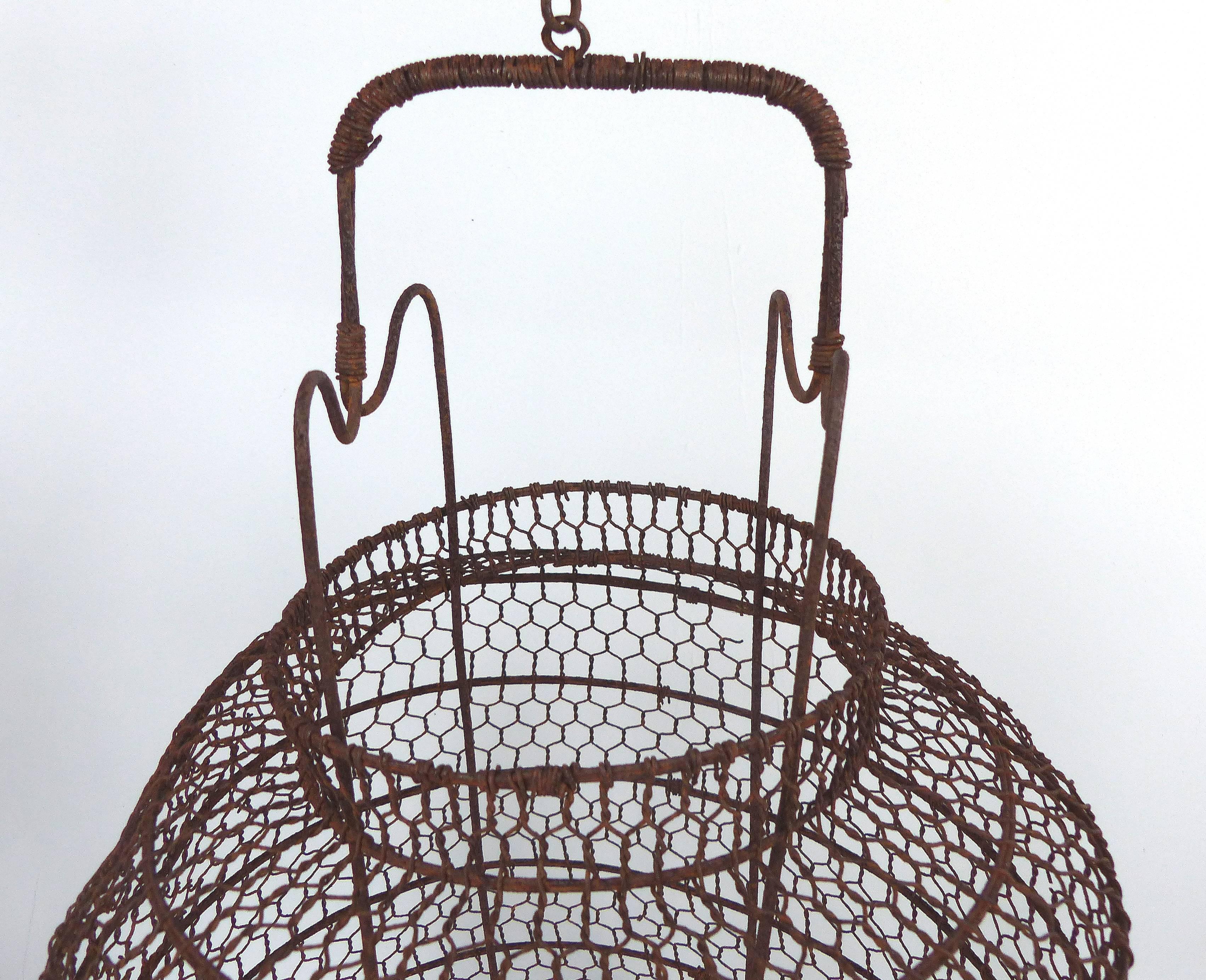 Offered for sale is a Chinese 19th century twisted wire candle lantern frame with the hanger and wood base. The frame shows corrosion from age and has some unevenness to the top side. Originally, the lantern would have had an interior fabric or
