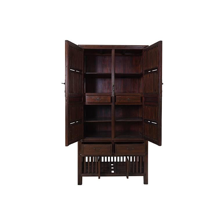 This 19th century square corner cabinet was designed with open latticework doors to display books, scholars' objects, vases, curiosites and antiques for an artist or collector. Originally from Beijing, it was carved from naturally aromatic cedar