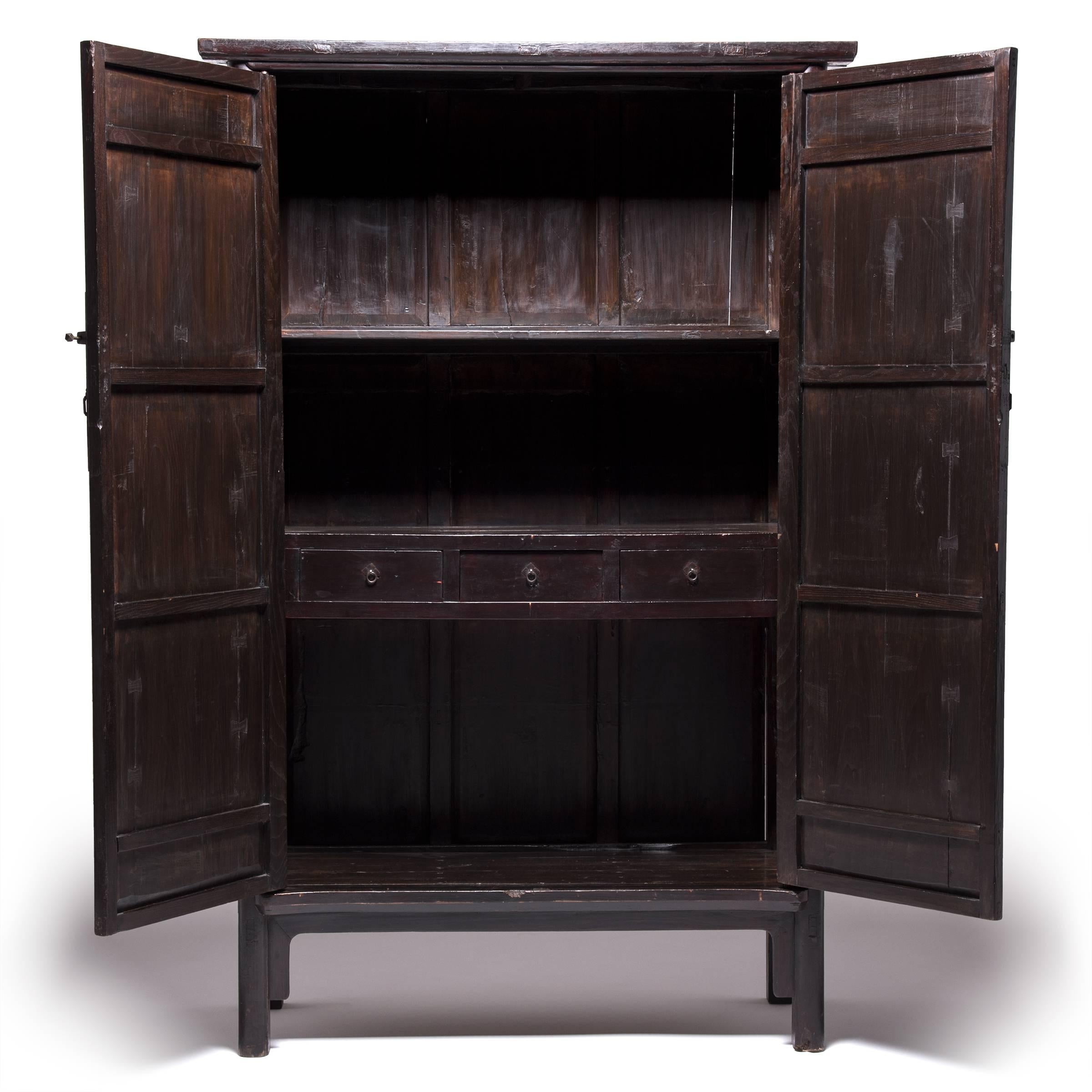 This striking mid-19th century cabinet made in Shanxi province takes its name from the elegant rounded wood detail that outlines its doors and frame. Austere in its simplicity, the cabinet showcases the grain and beautiful brown color of Chinese