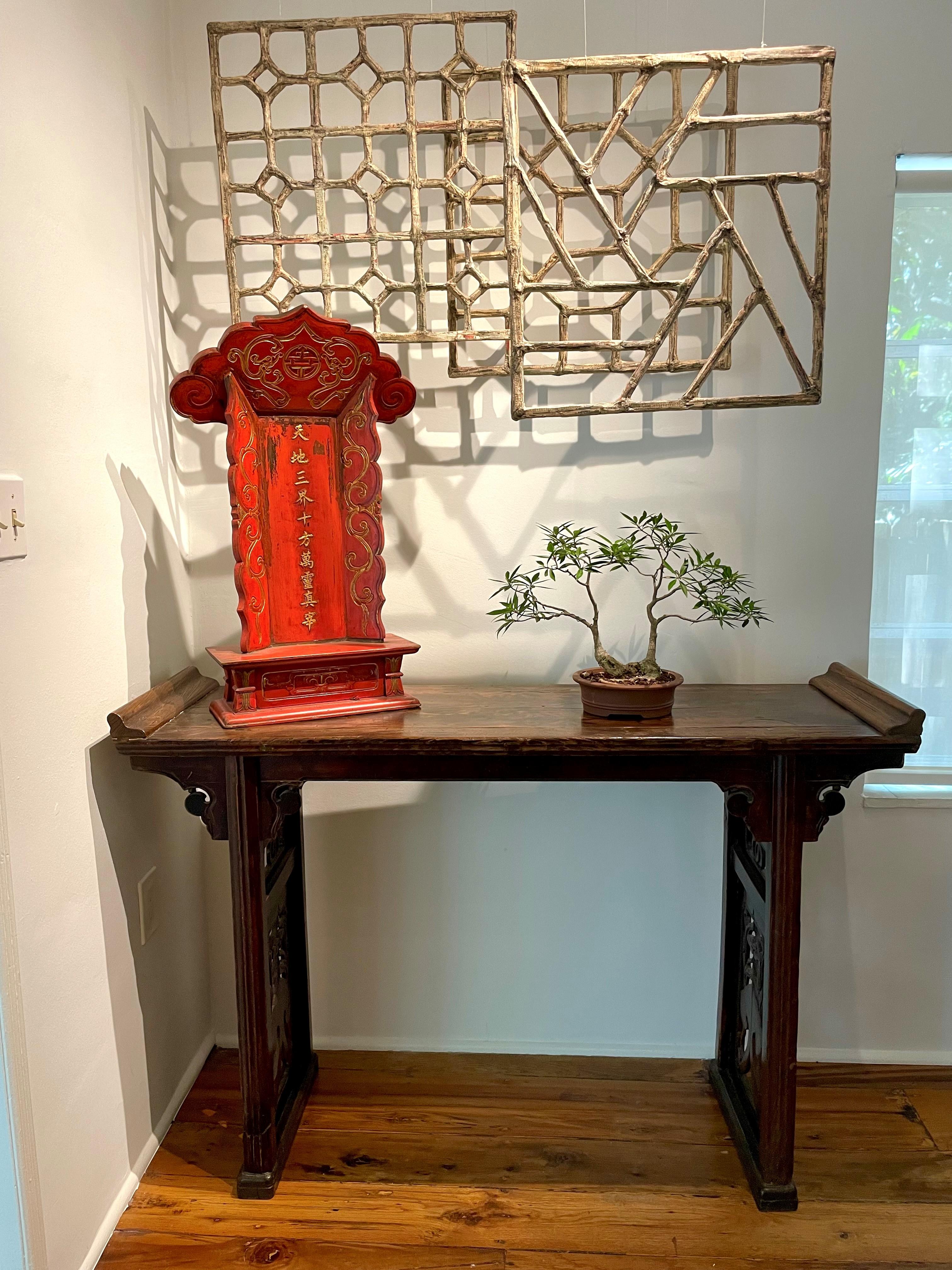 Dieser wunderschön geschnitzte Altartisch aus dem 19. Jahrhundert ist traditionell mit Schlitz und Zapfen aus Walnussholz (Hetao Mu) gefertigt. Die Schürzen an den Seiten sind mit Blumen-, Lotos- und Ruyi-Symbolen verziert. Ruyi ist ein altes Symbol