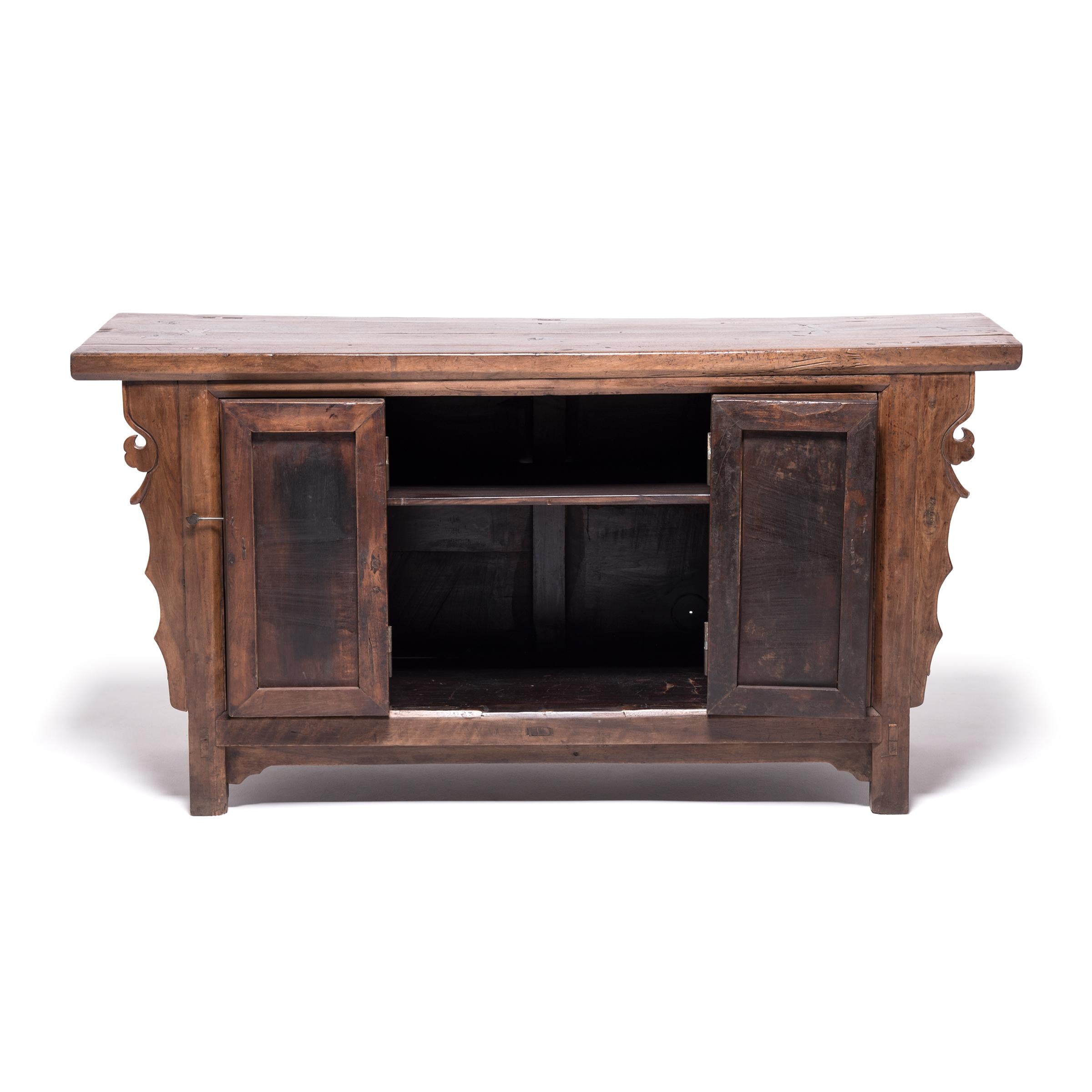Crafted of golden walnut, a wood prized for its open-grained texture and warm tones, this 19th-century chest balances traditional simplicity with the quiet flair of its cloud spandrels. The plank top features a butterfly patch, a wabi-sabi mark of